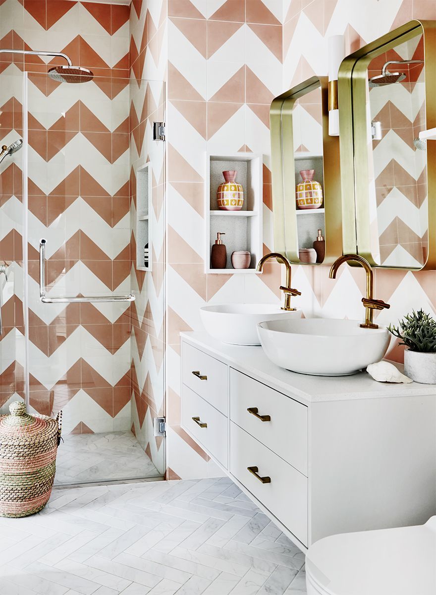 This bathroom design by E&A Interiors featured chevron wall tiles that liven up the space