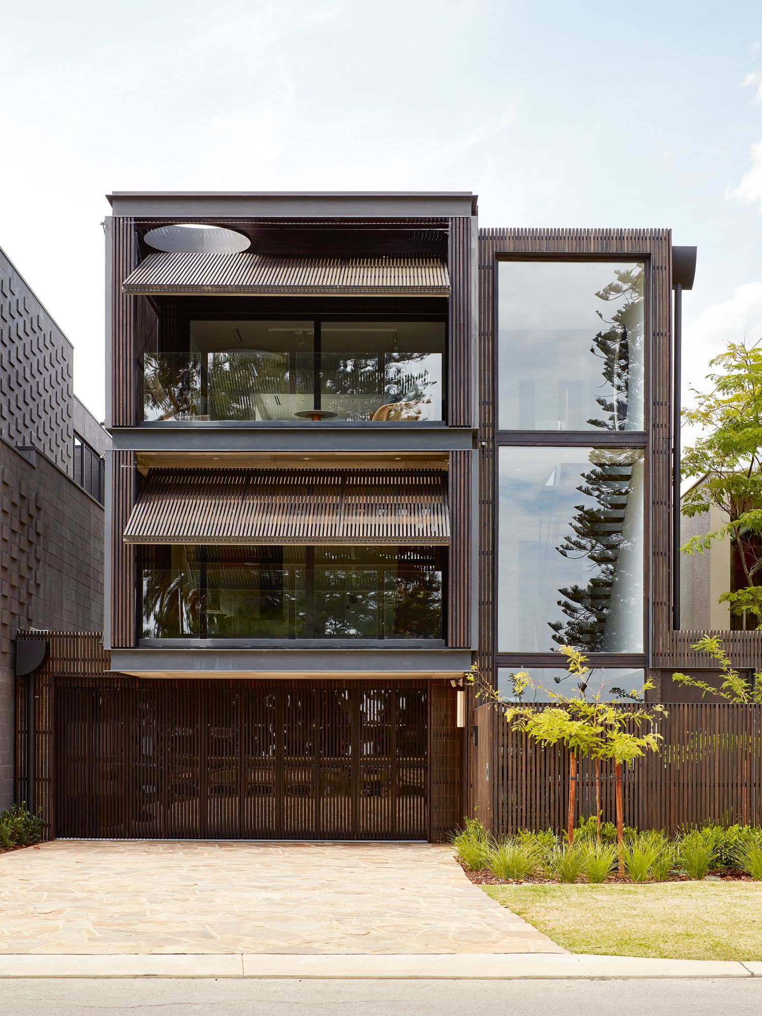The facade features operable screens in dark wood
