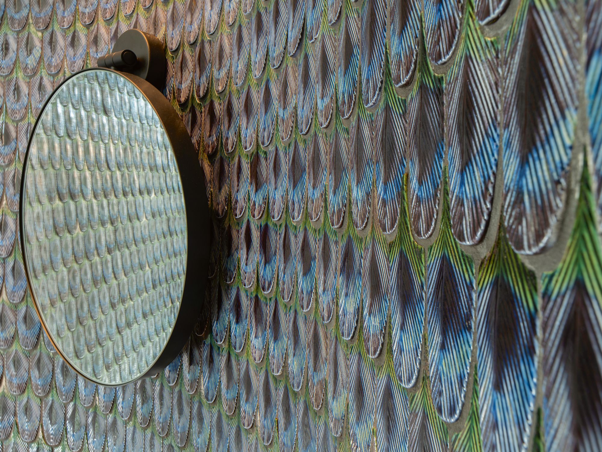The powder room is decked in a wallpaper inspired by the feathers of a peacock