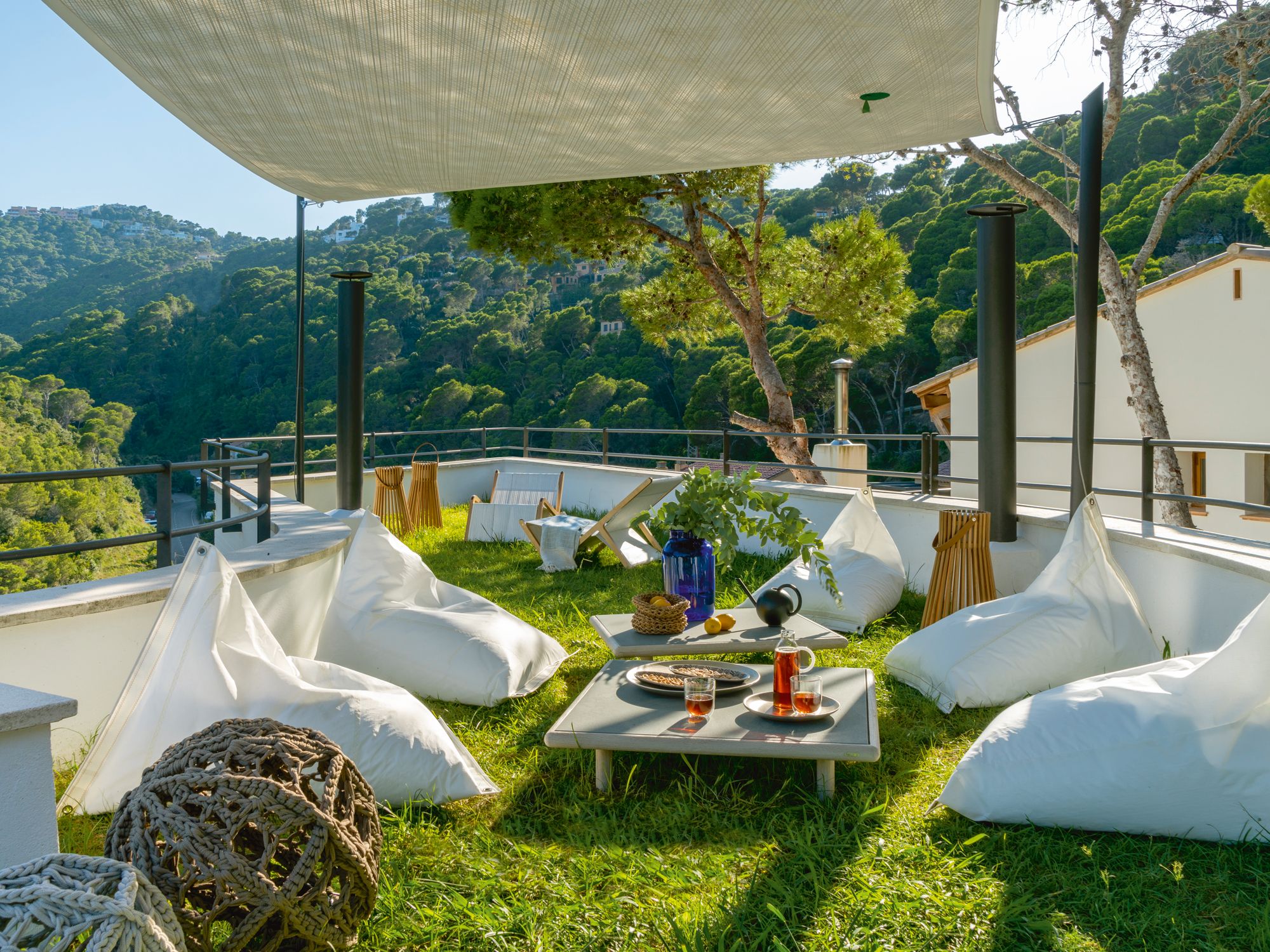 The exterior yard is furnished with Barlovento & Sotovento beanbags, lamps from Gloster and Fina Badia, Dvelas poufs and side tables from Roda
