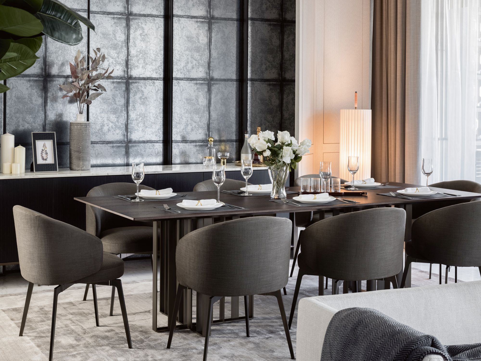 The silver-leaf wall panels add a subtle shine to the dining room; to the left of the lift is a console with a Marquina marble top
