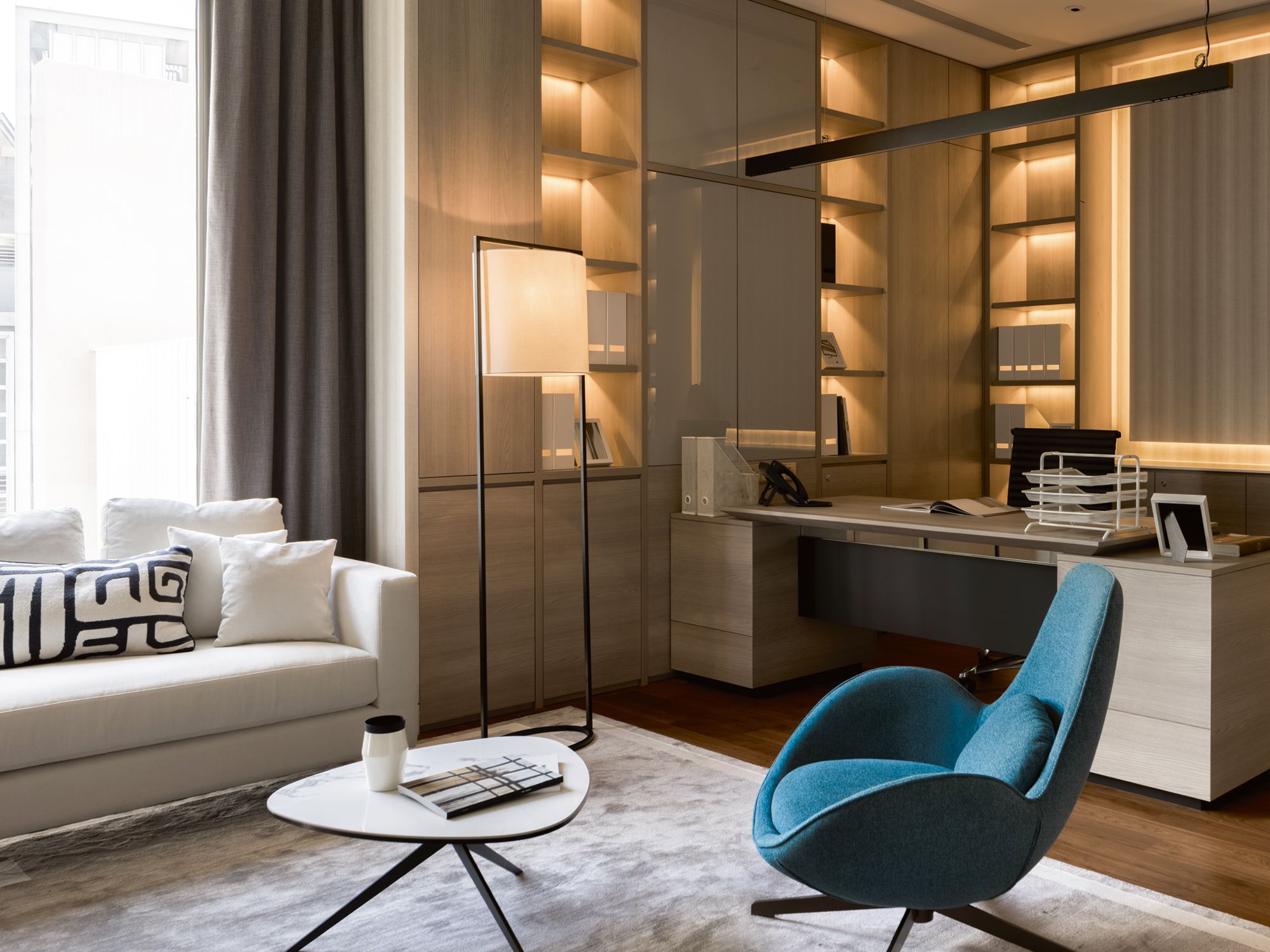 A blue armchair adds a pop of colour to the handsome home office