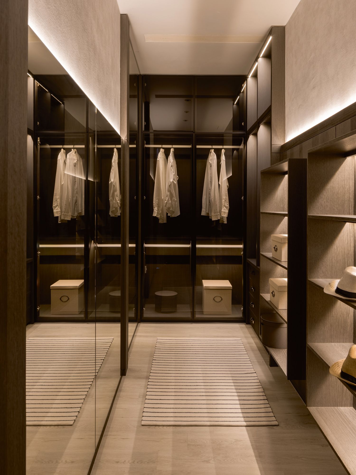 Mirrored panels in the walk-in wardrobe expand its sense of space