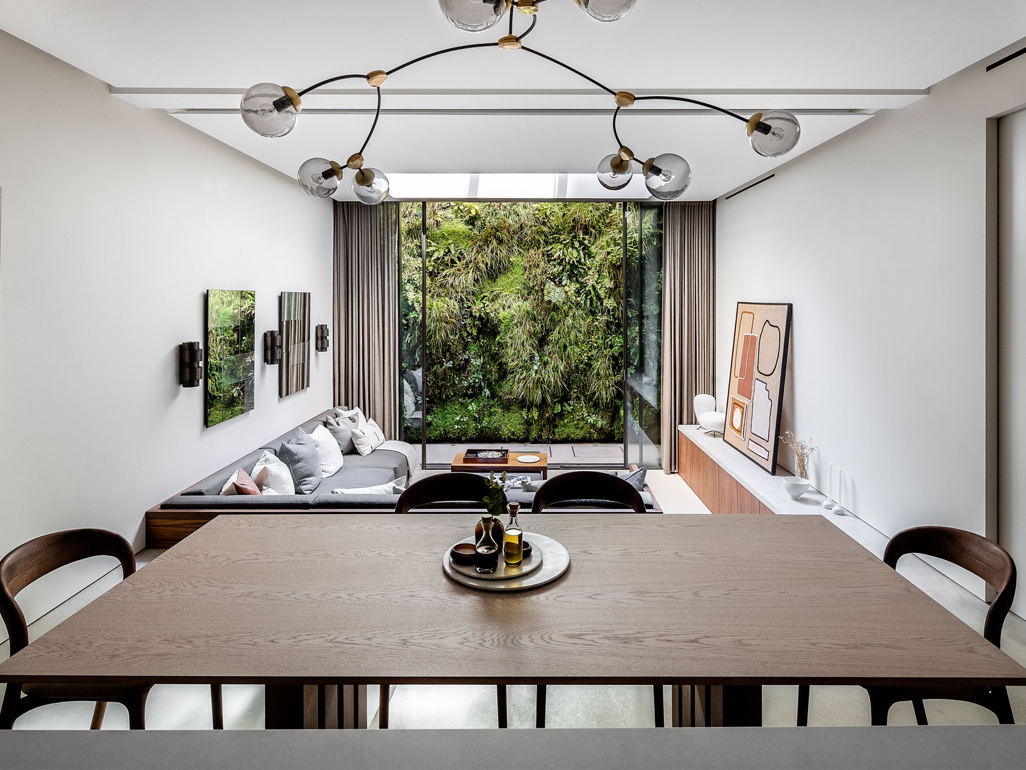 Handmade in Brighton, a bespoke pale timber table designed by Echlin forms the informal dining area, accompanied by walnut chairs around
