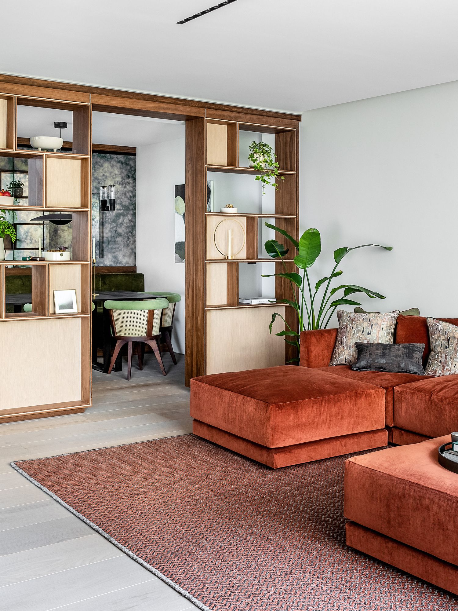 Tall shelves form an open partition between the living and dining area