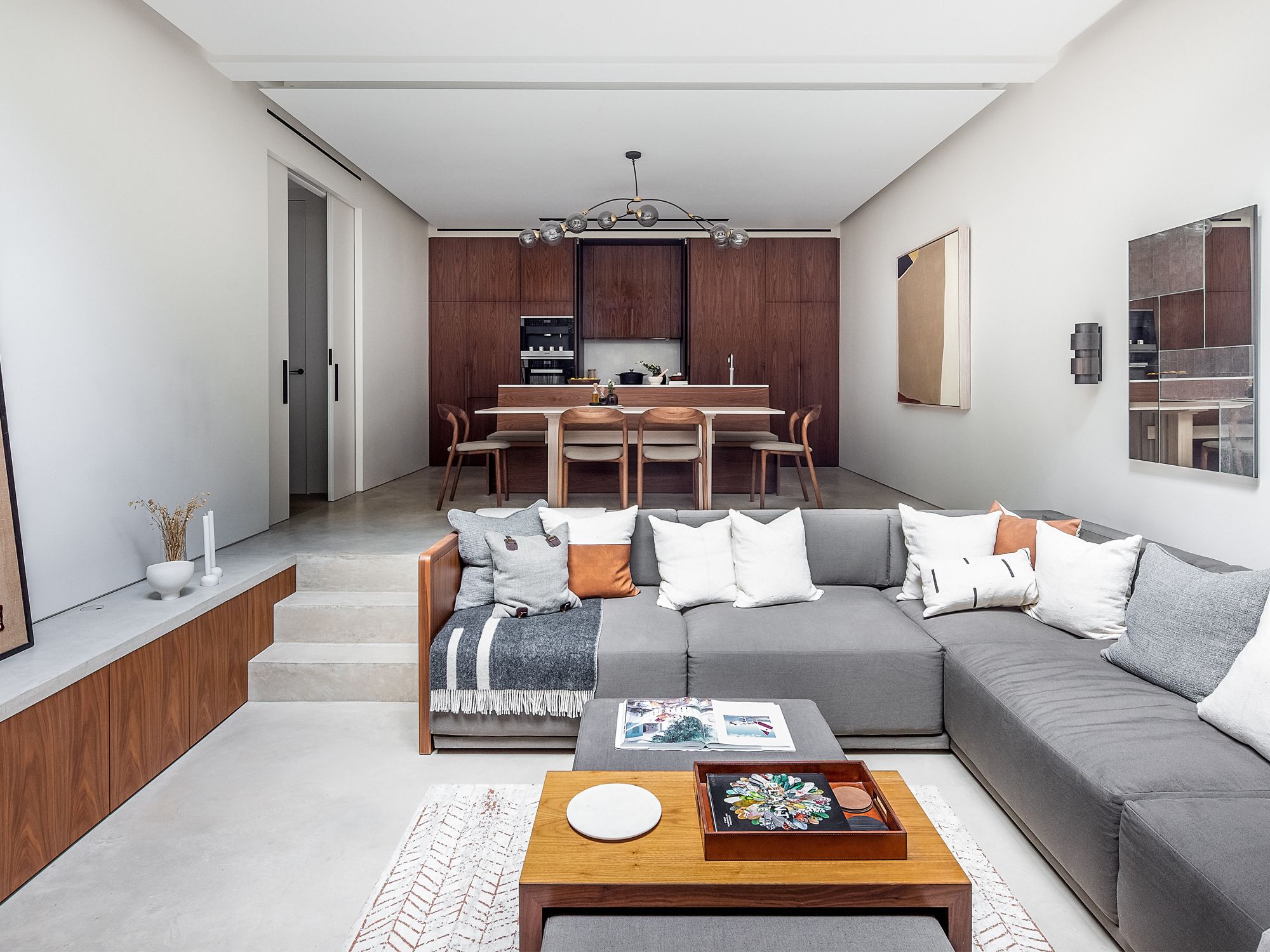The sunken living room includes a corner sofa made by Echlin in Oxfordshire, a Jacob’s Ladder rug by Floor Story, and artwork from Aishah by LRNC