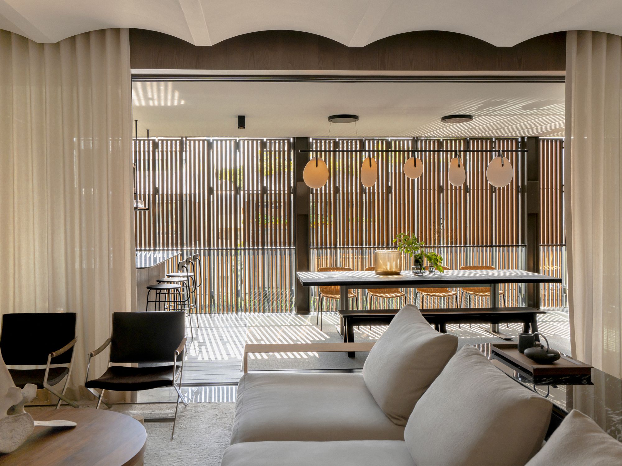 The living room is furnished with a sofa and armchairs from Flexform, a coffee table from Yucca and a sideboard designed by Gabriel Tan Studio
