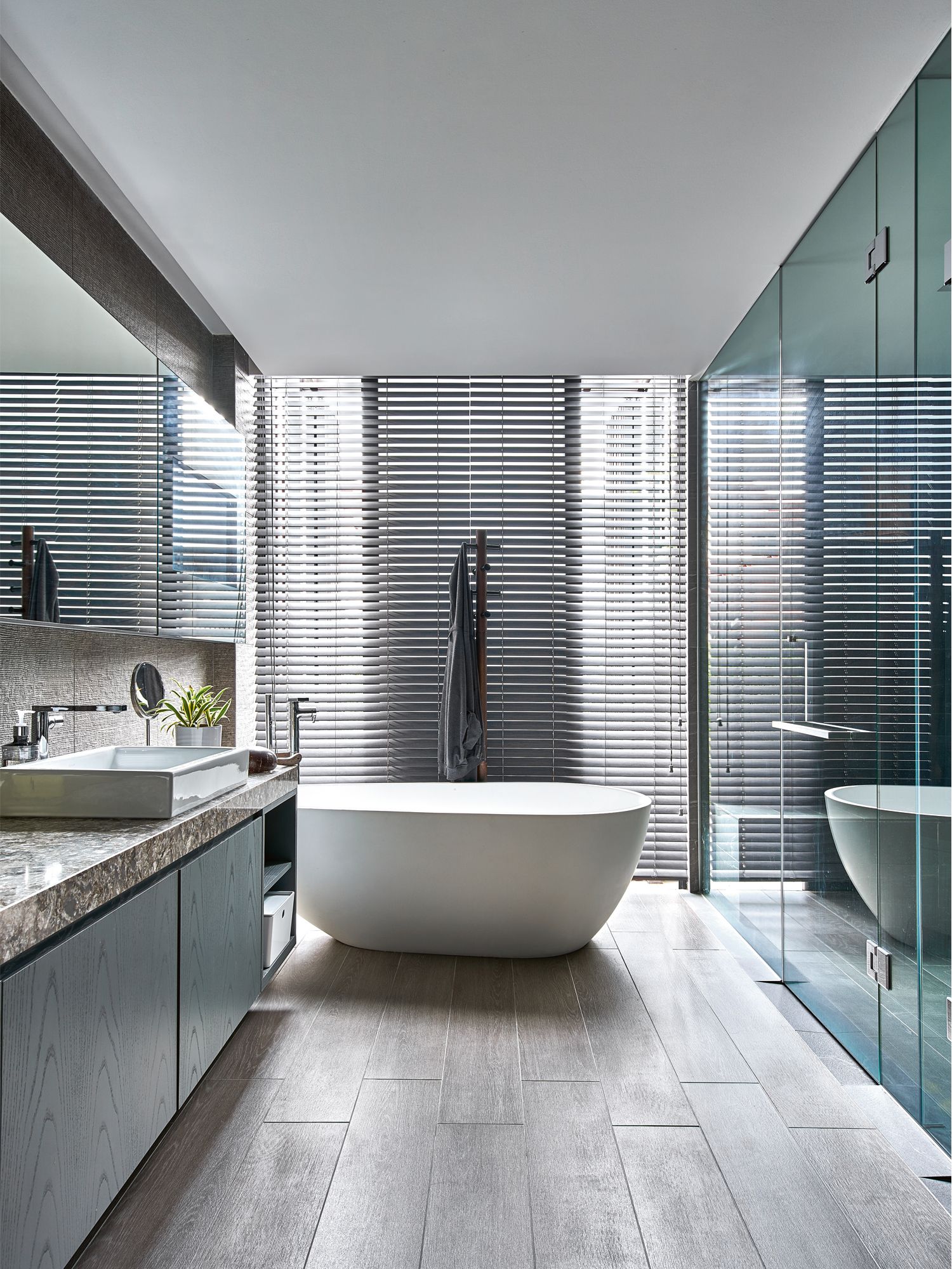 The master bathroom is a light-filled space furnished with a freestanding bathtub, fittings from Kohler and a steamer cubicle with retractable screens
