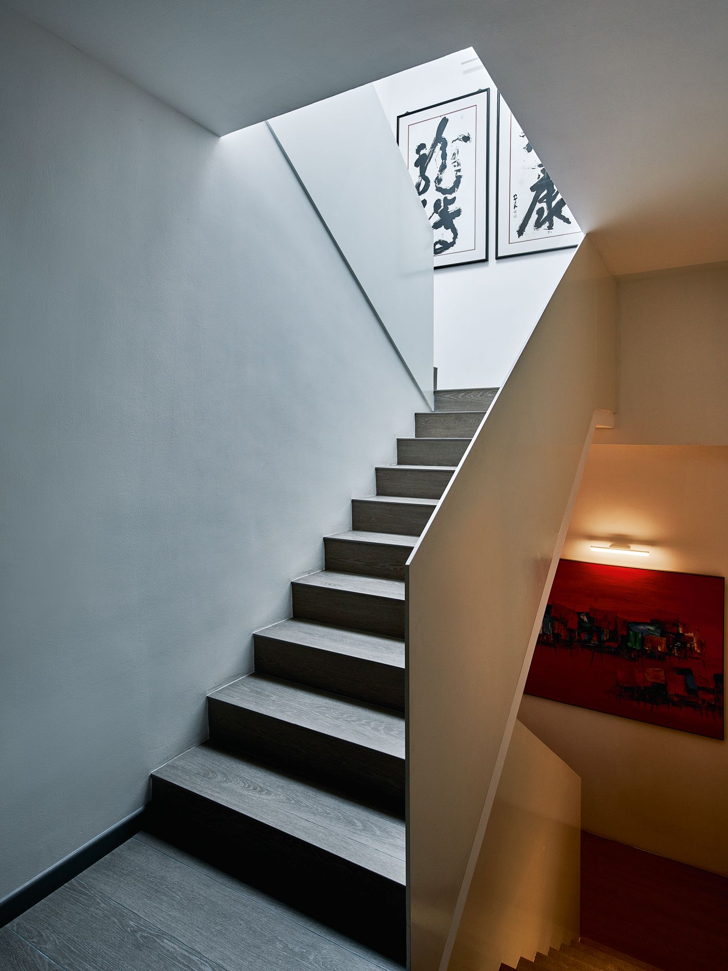 Calligraphy works and an abstract art piece create visual interest in the stairwell