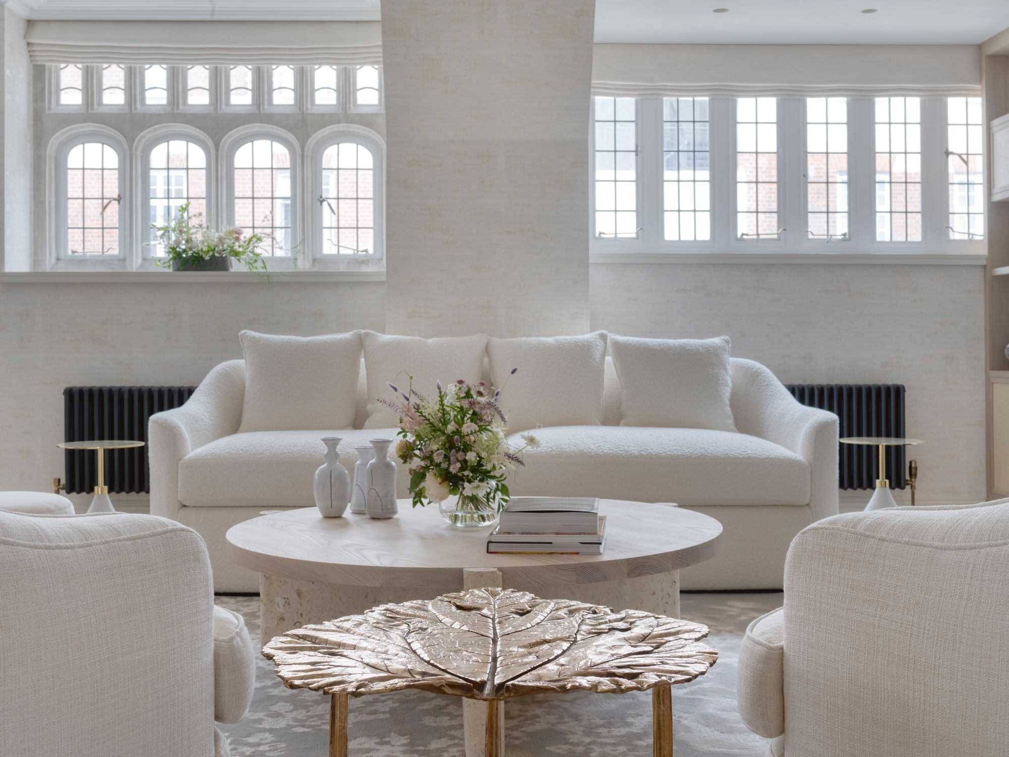 A gold-leaf side table by Clotilde Ancarani adds a glamorous touch to the monochromatic living room