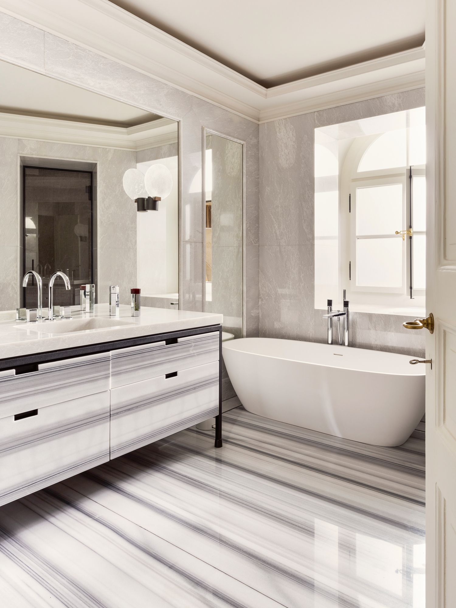 The striped pattern on the cabinetry and flooring accentuates the linear proportions of this bathroom