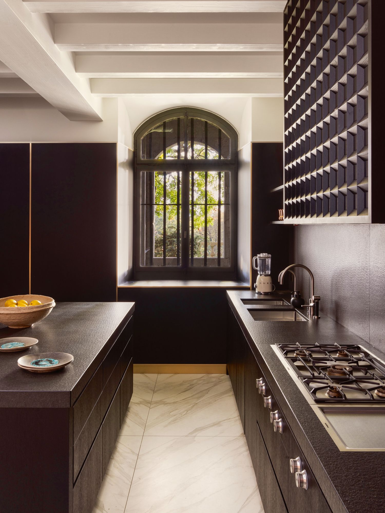 The kitchen is decked in Neolith Calacatta gold marble flooring and fitted with lacquered oak wood cabinets and countertops inflamed black Zimbabwe granite