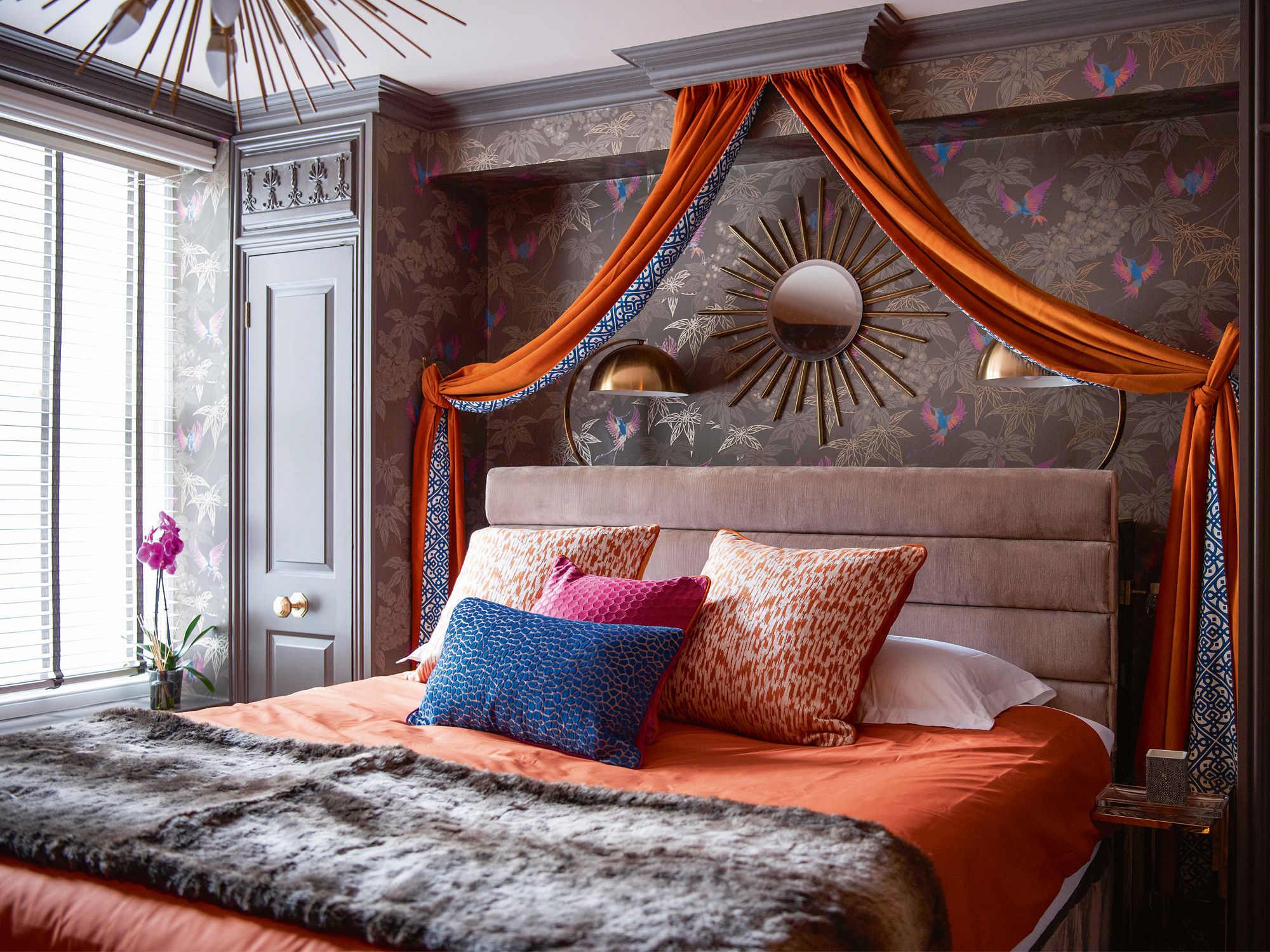 Tangerine tones on the curtains, cushions and bedlinen liven up this bedroom’s serene grey palette