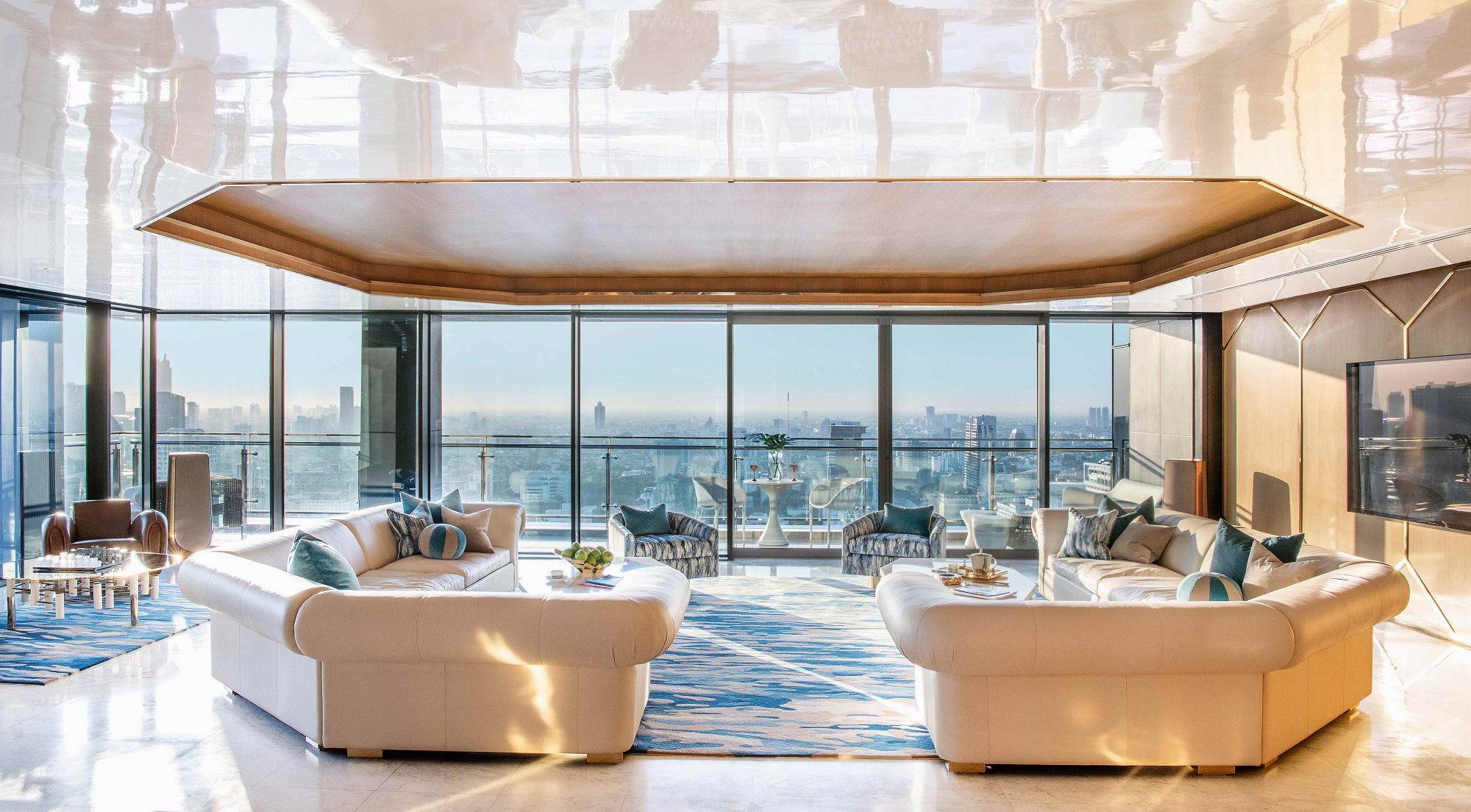 The living room in this Bangkok penthouse features bespoke rugs and an incredible skyline