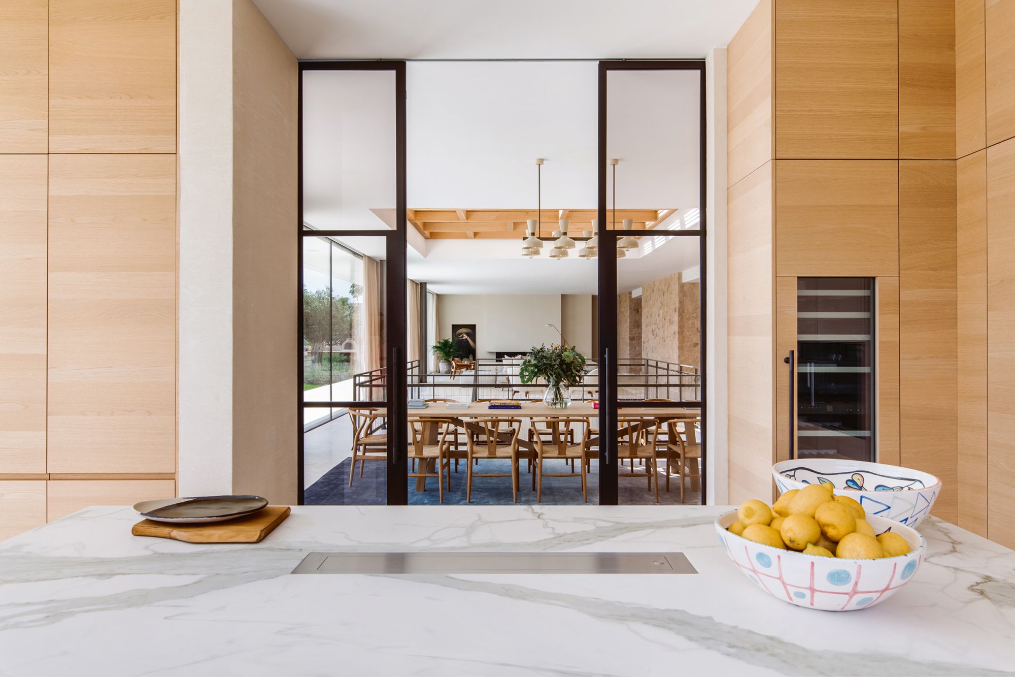 The kitchen looks out to the dining space, with the Carl Hansen Wishbone chairs