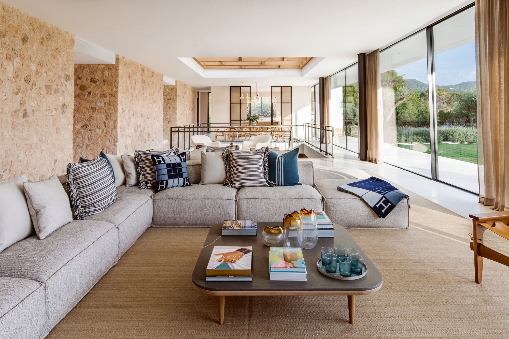 The living area incorporates a sectional set on a Luke Irwin custom hemp rug