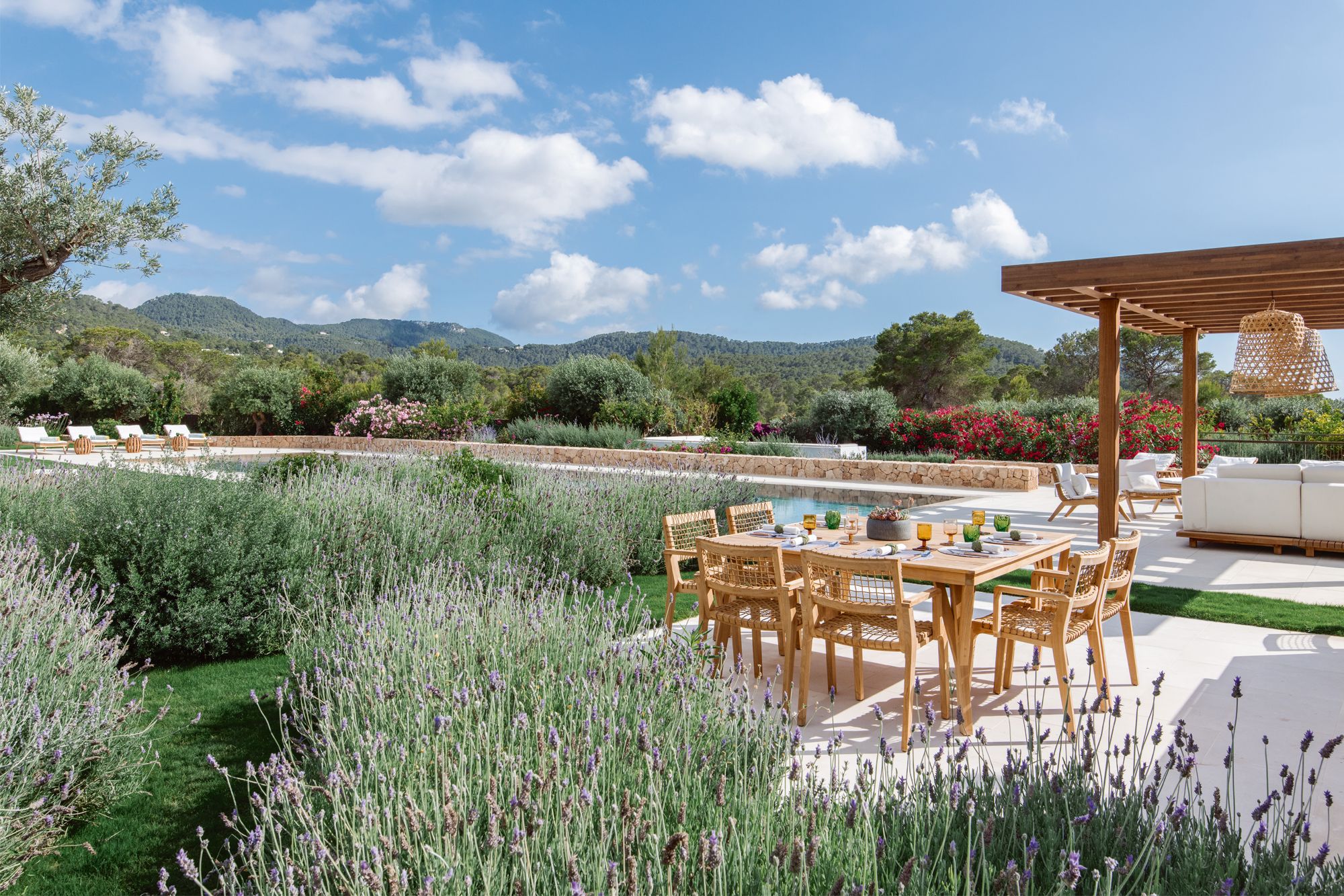 The landscaped garden sits pretty next to the pool and a pergola, which are complemented with natural teak outdoor furnishings