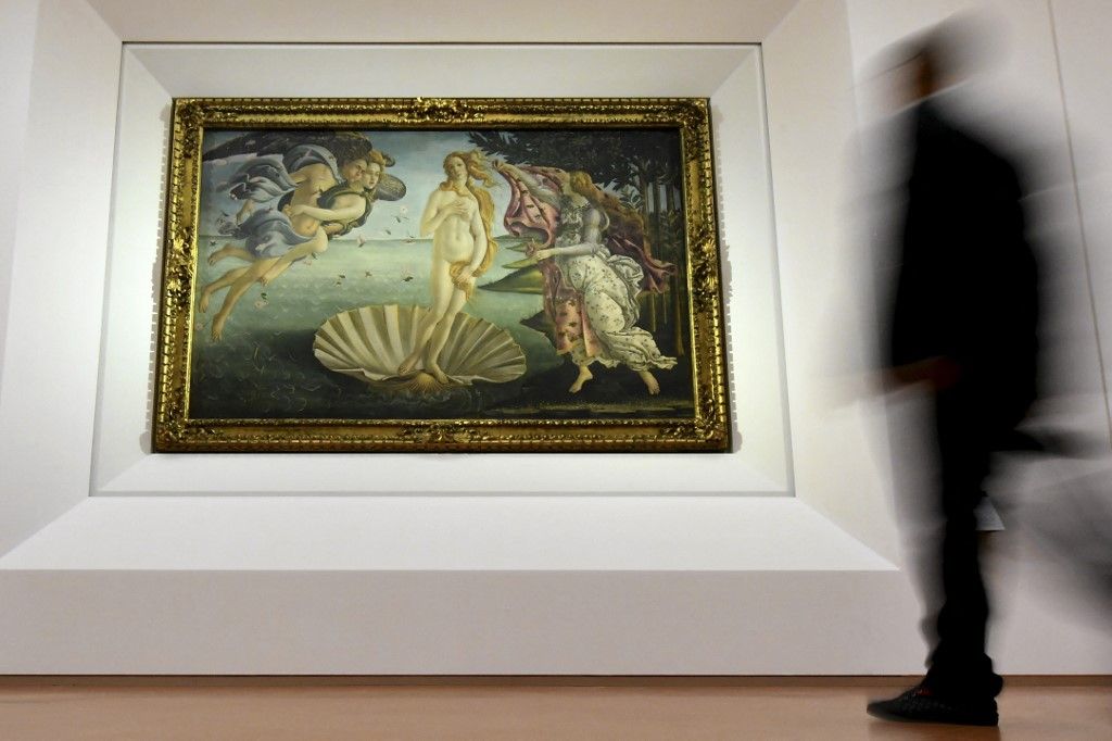 A person walks past the "The Birth of Venus" painted in 1485 by Italian painter Sandro Botticelli during a press preview for the reopening the rooms dedicated to Pollaiolo and Botticelli, at the Uffizi Gallery in Florence, on October 17, 2016. - The articulation of the space has been reorganized for to faciliate the visit thanks to a large donation by the "Friends of Florence Foundation". (Photo by ALBERTO PIZZOLI / AFP)