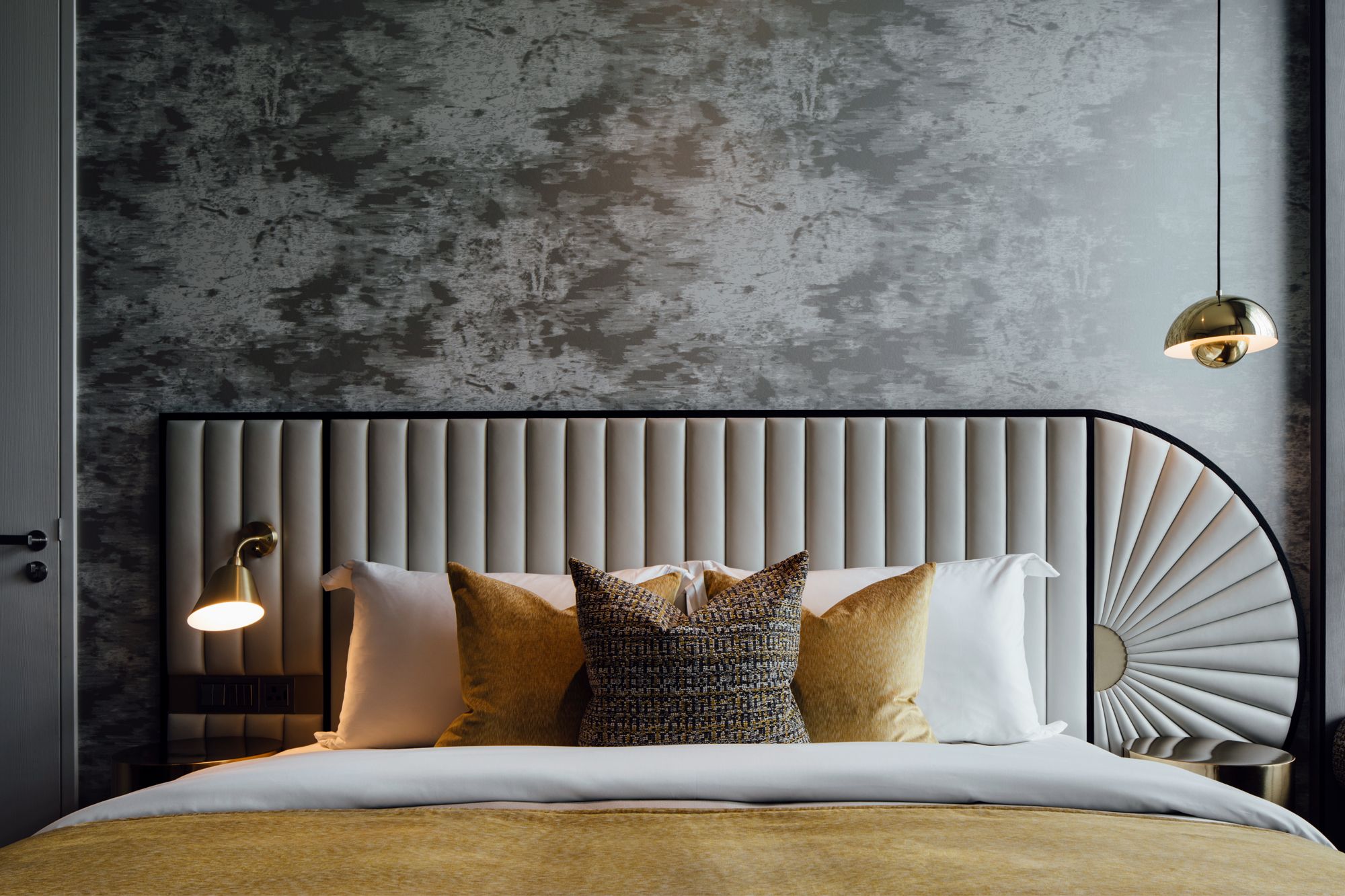 This guest bedroom features a unique headboard with elegant hand-carved panels