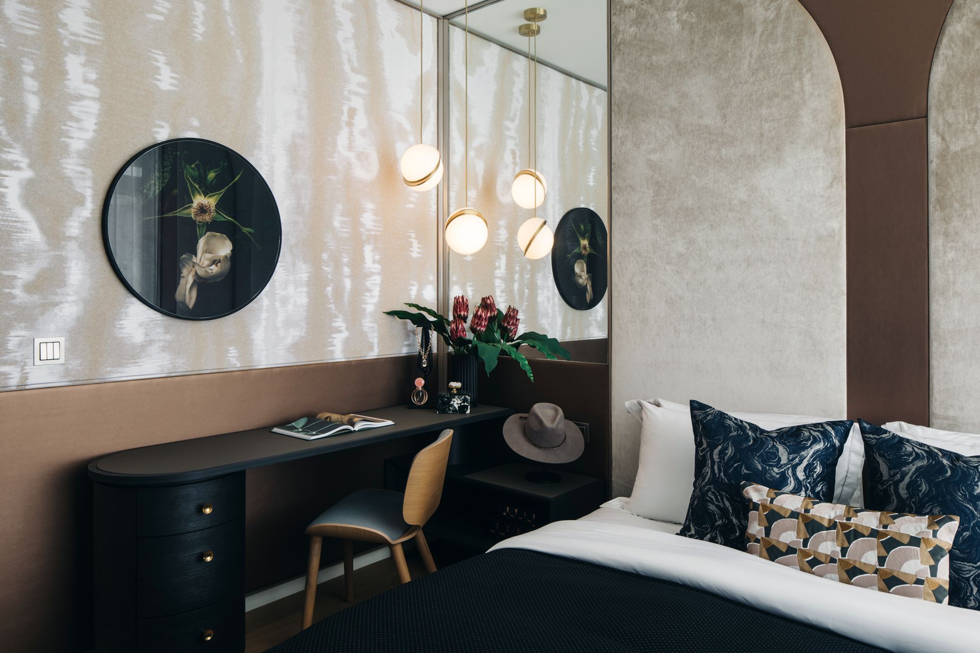 Wallpaper and upholstered fabric panels on the headboard elevate the rich, tactile look of this bedroom in the Night unit