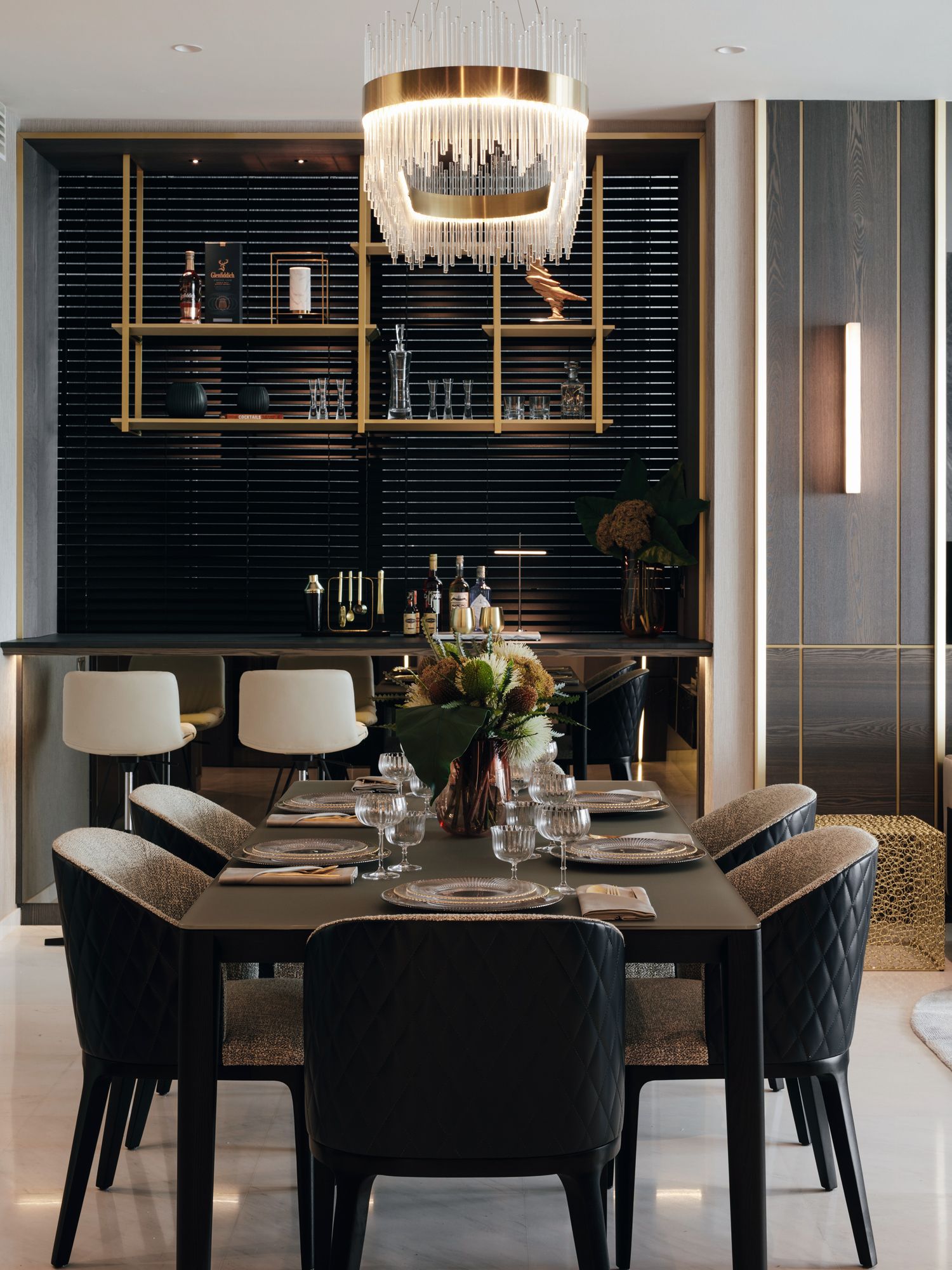 Metallic trimmings on the grand chandelier, wall and shelves contribute to the glamorous atmosphere in the dining room