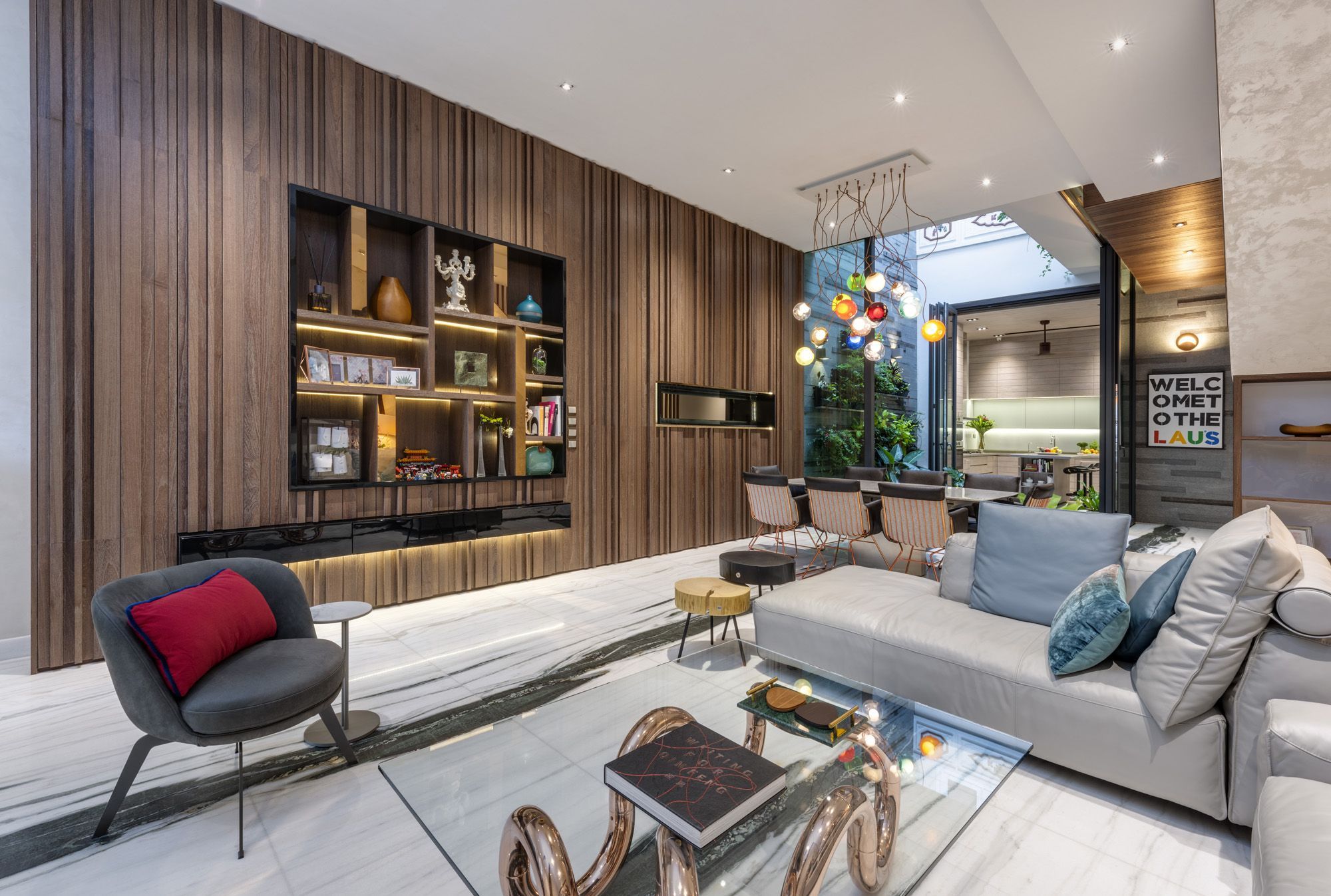 The playful coffee table and statement lighting piece adds a dose of vibrance to the living room
