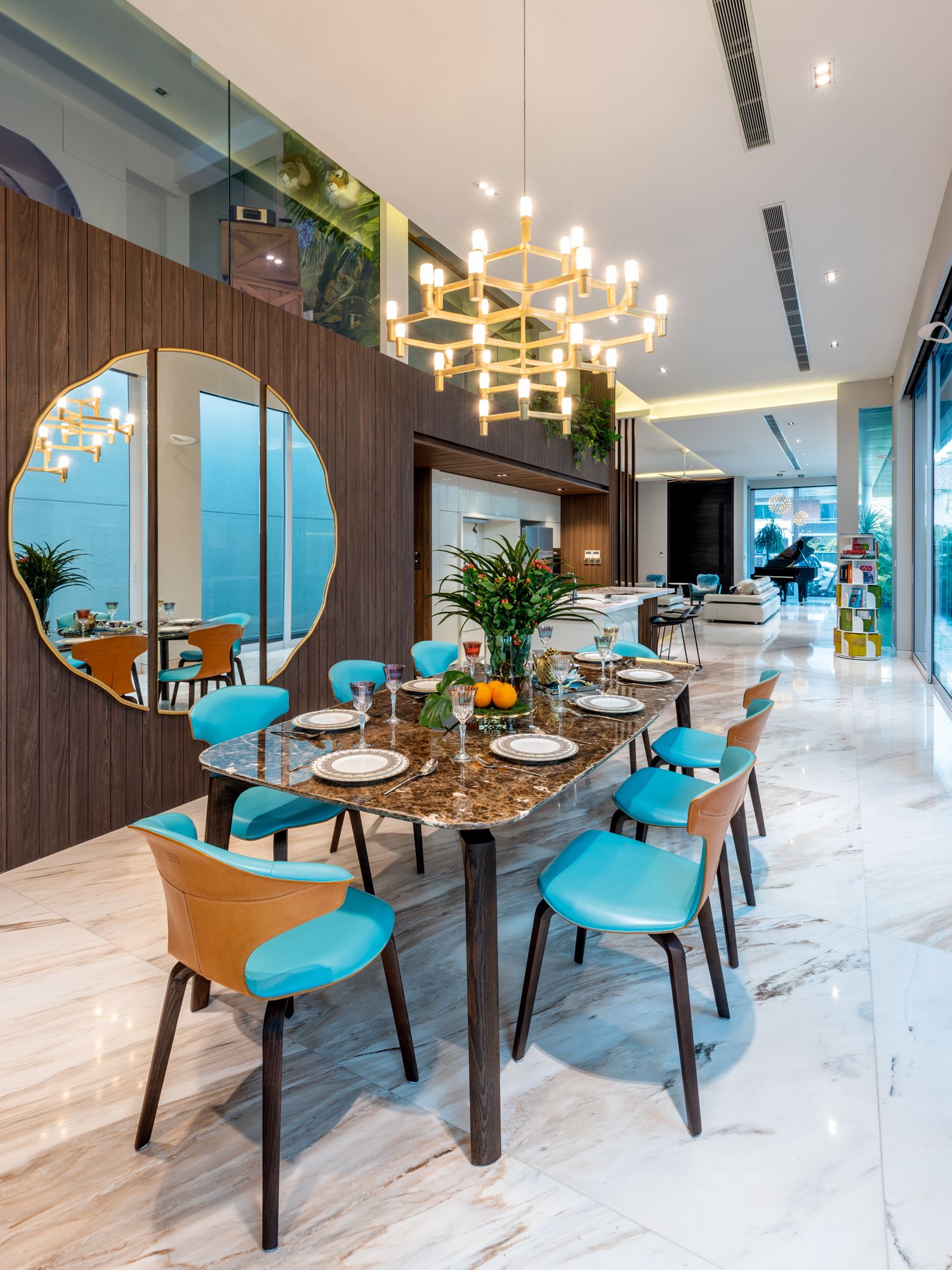 The teal hue of the Poltrona Frau Montera chairs adds a lively touch to the dining area