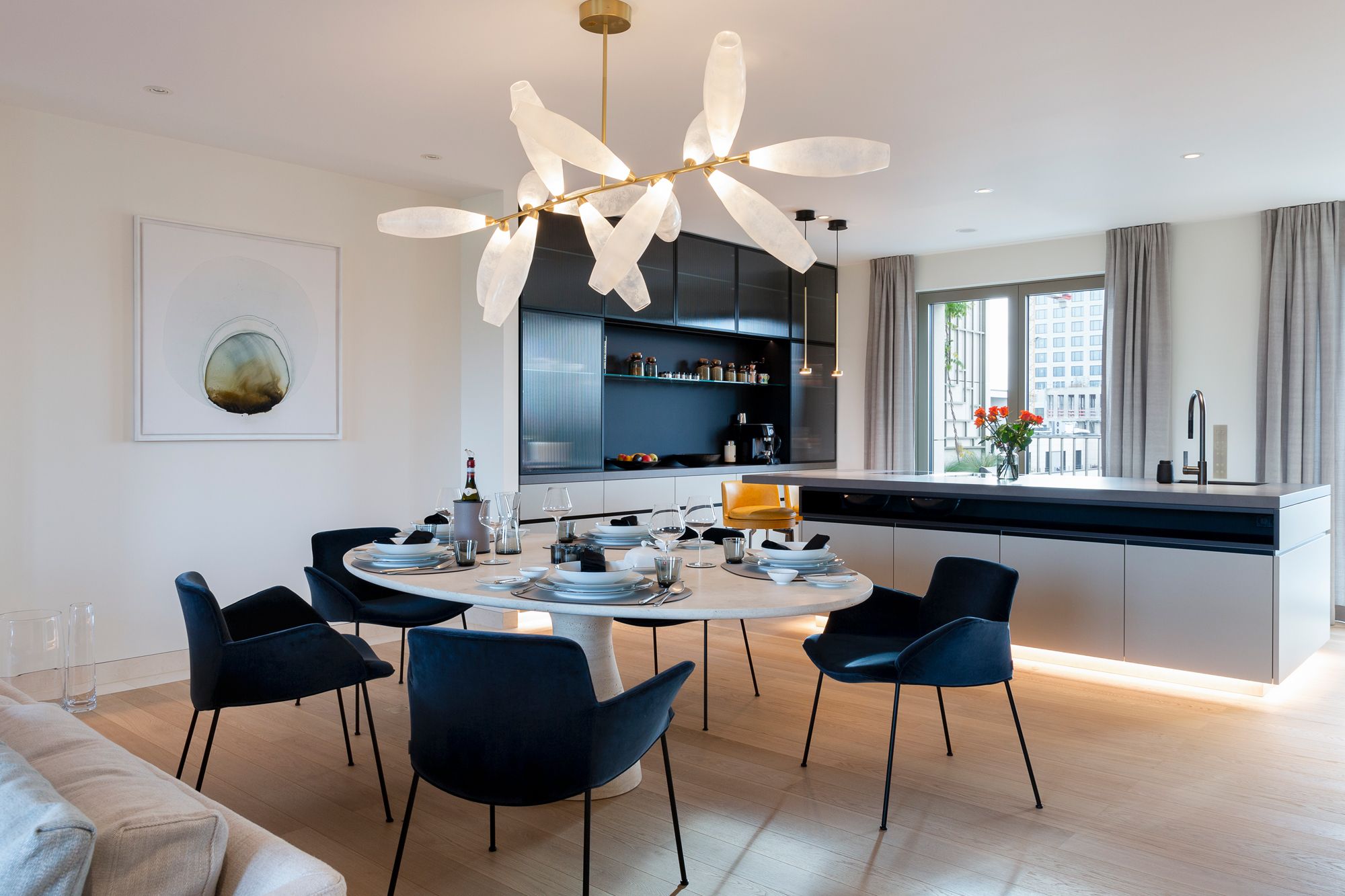 The expansive dining and kitchen area is flooded with natural light, courtesy of the large windows