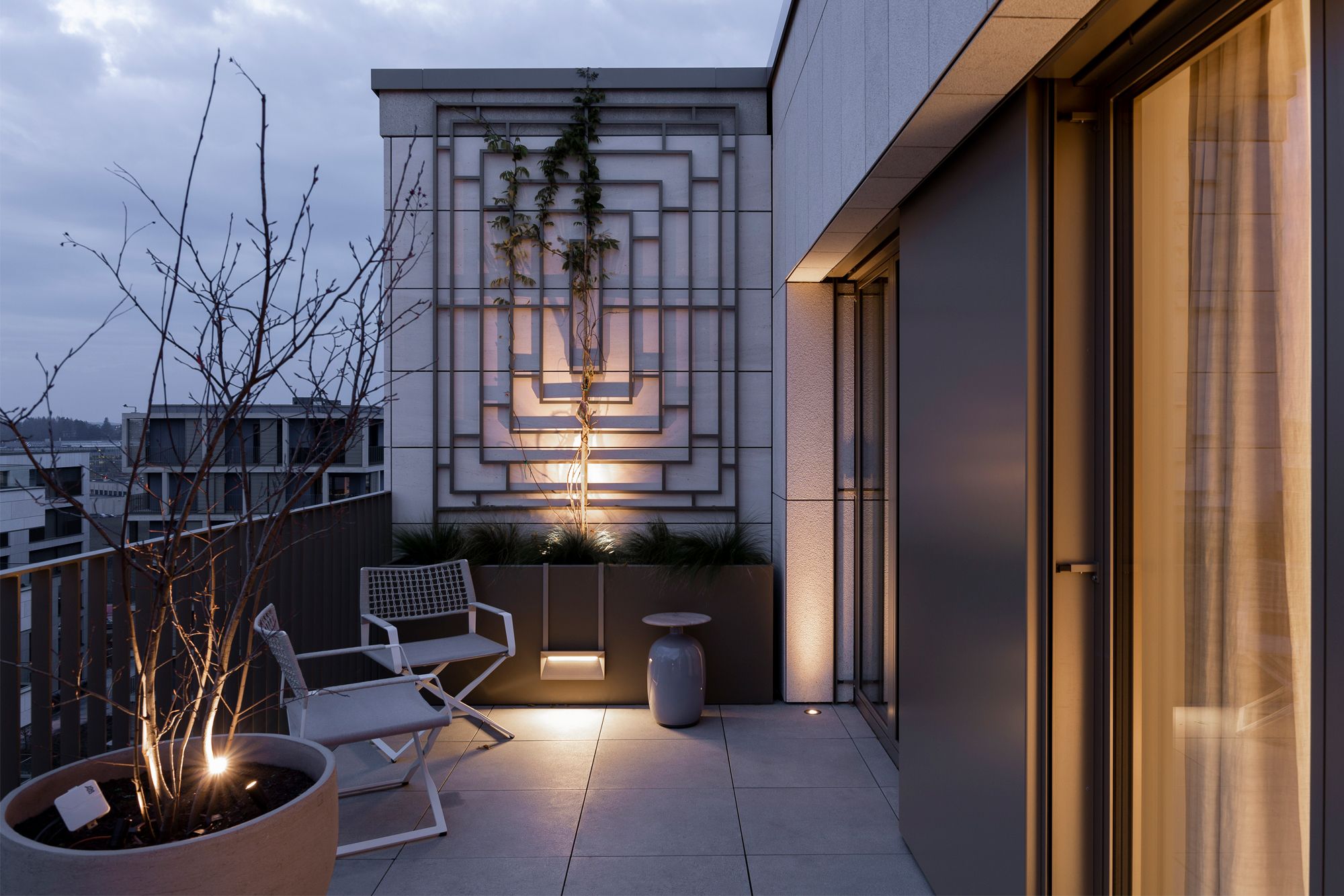 The rooftop terrace provides a private panoramic view of the city, enhanced at night with soft ambient lighting