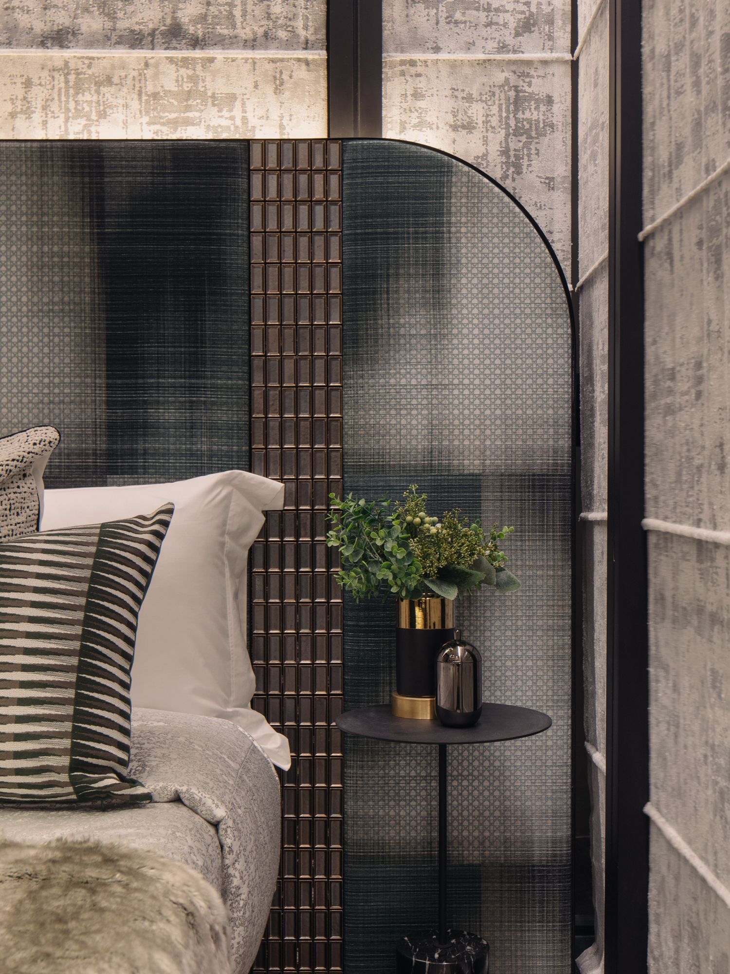 The grid-like patterns on the upholstered headboard and walls create a unified look