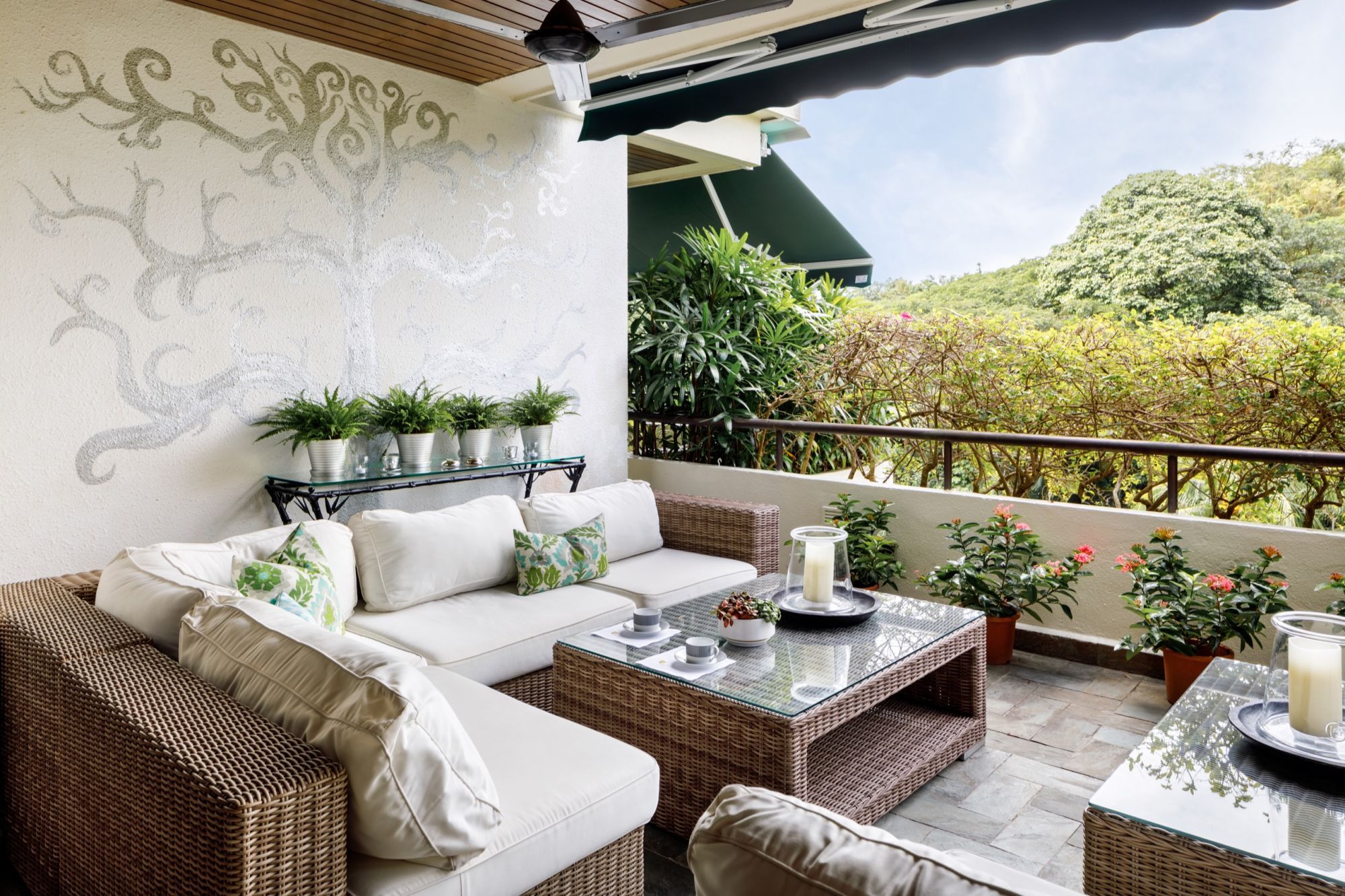 This spacious balcony is transformed into an outdoor oasis with outdoor rattan furniture and plenty of plants