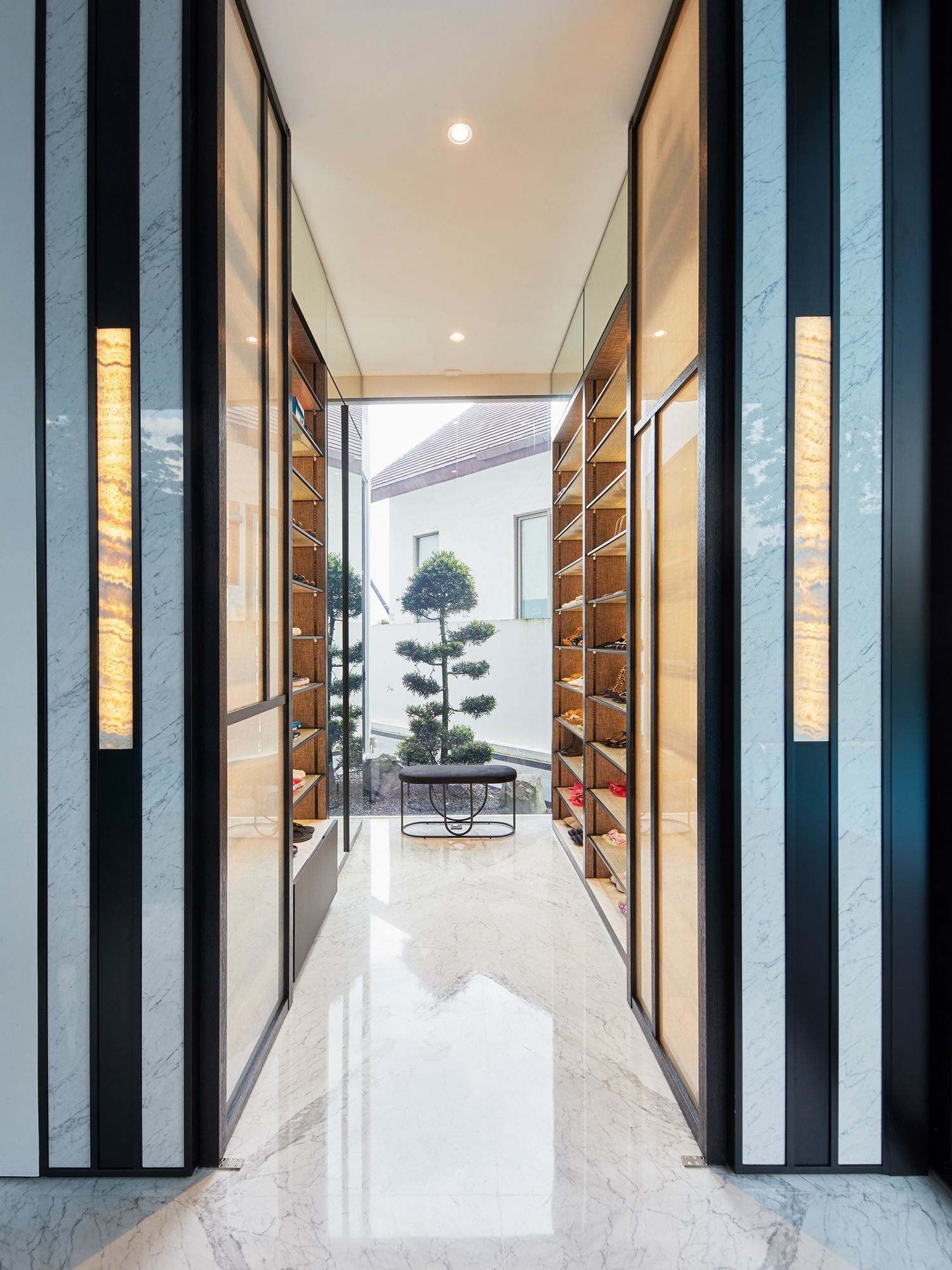 Inspired by fashion boutiques, interior design firm KGID designed a stunning walk-in shoe cabinet for a client who loves footwear