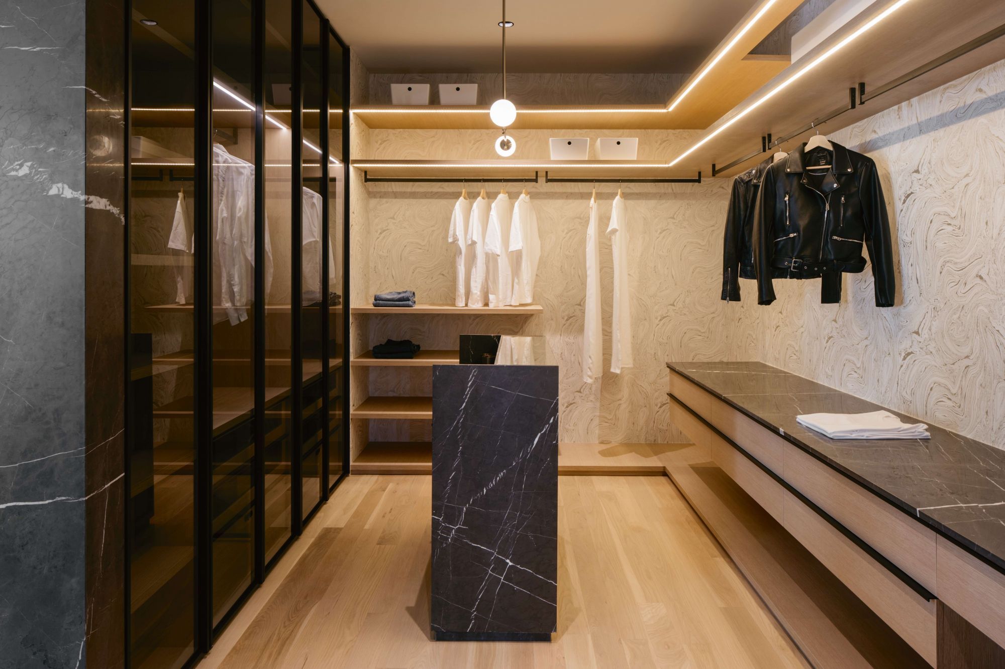 Designed by Ming Architects, this monochromatic walk-in wardrobe features a dynamic mix of storage options