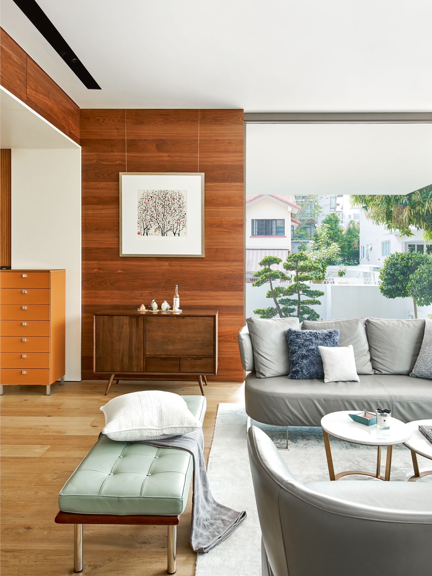 A pale green bench and orange cabinet add vibrancy to the living area