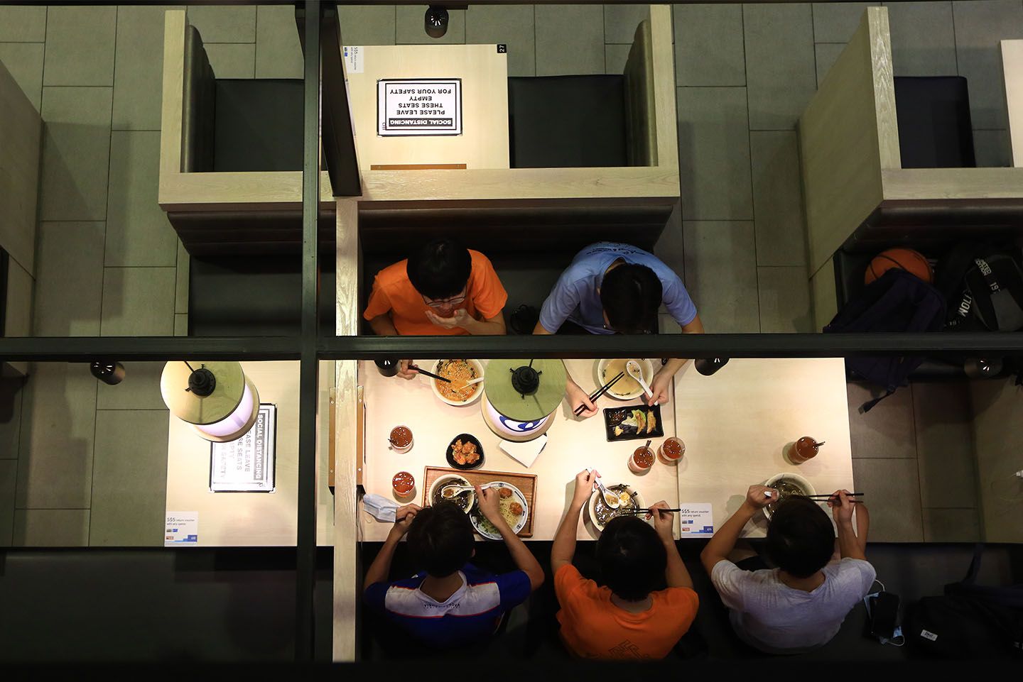 People dine-in at a restaurant with tables seen marked out for safe distancing. (Photo: Suhaimi Abdullah/Getty Images)