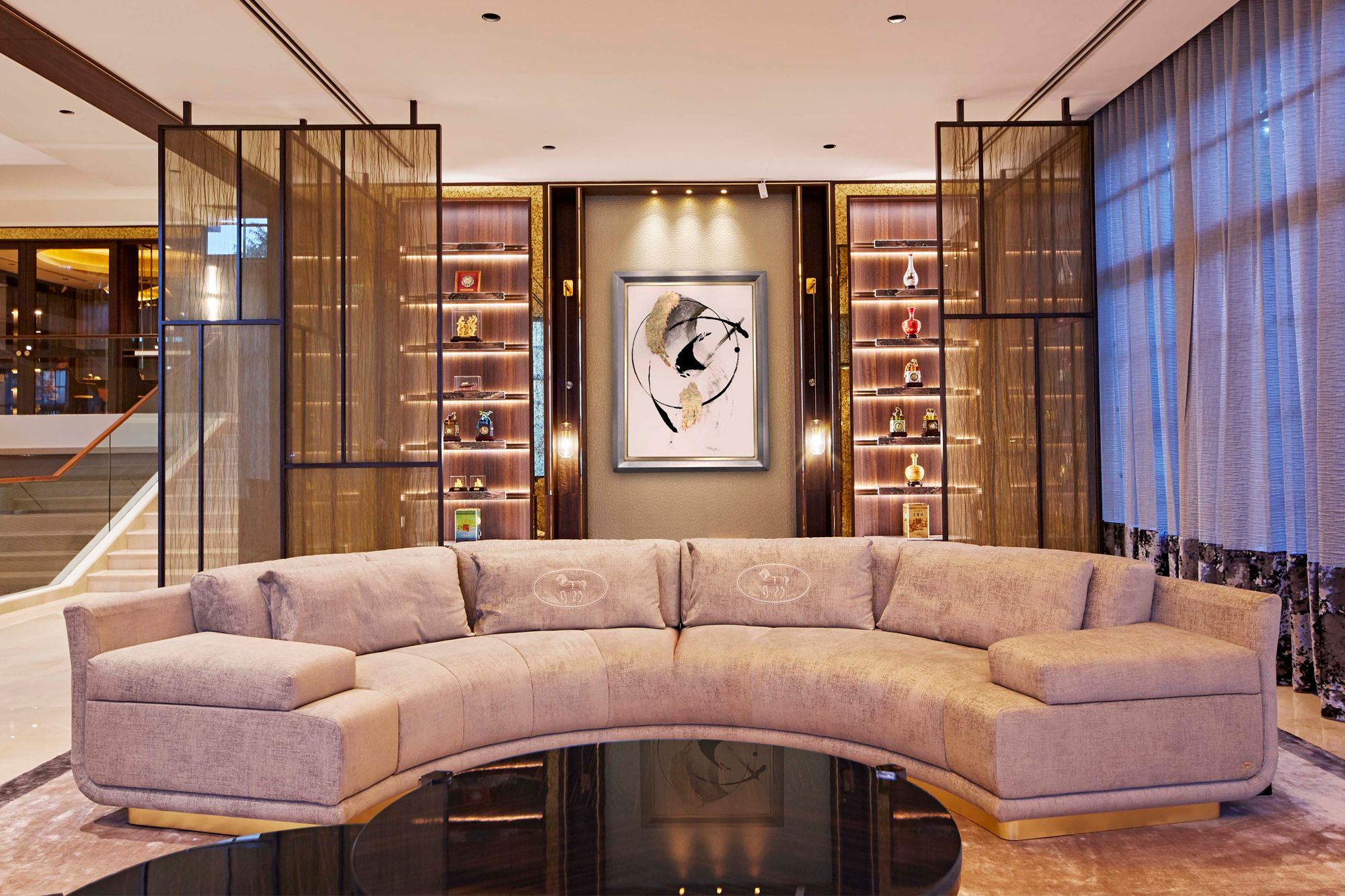 A formal living room with a large curved sofa from Fendi allows the family to host guests comfortably
