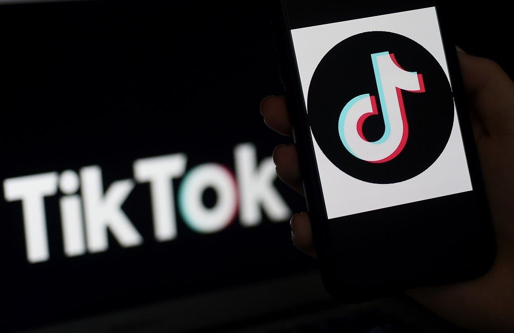 (FILES) In this file illustration photo taken on April 13, 2020 the social media application logo of TikTok is displayed on the screen of an iPhone in Arlington, Virginia - TikTok, the social media platform that is all the rage with the world's teens, could break away from its Chinese parent to evade a US ban, a top White House adviser said on July 16, 2020. "We haven't made final decisions (on the ban) but as has been reported in some places, I think TikTok is going to pull out of the holding company which