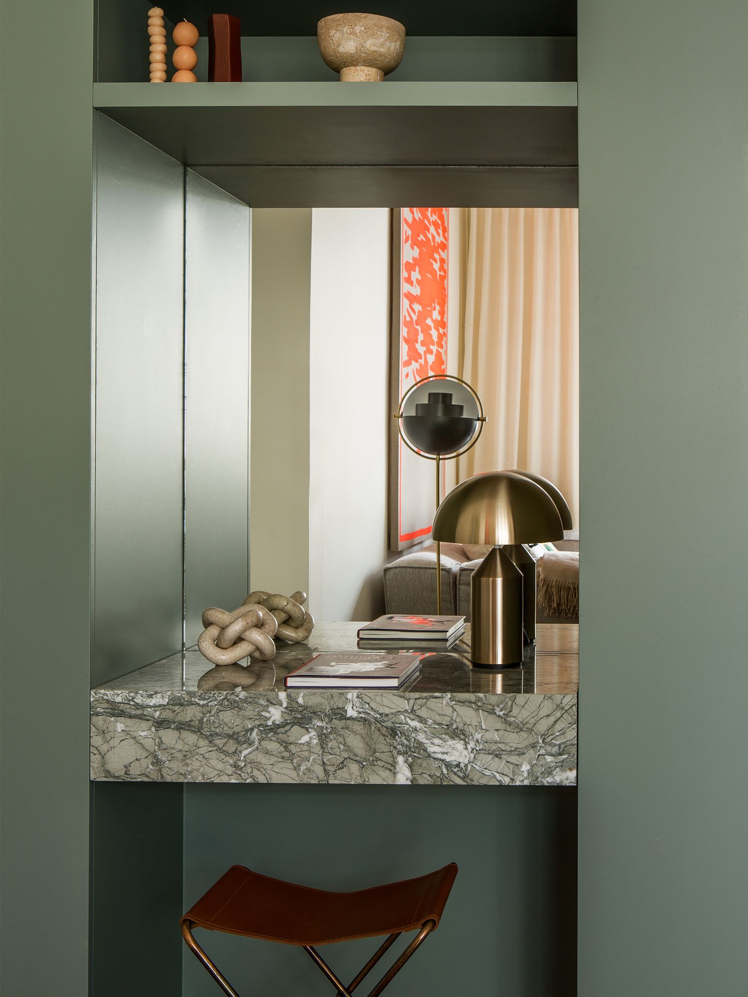 A study nook within the kitchen area features the Atollo lamp from Oluce and a brass stool from Broste Copenhaguen