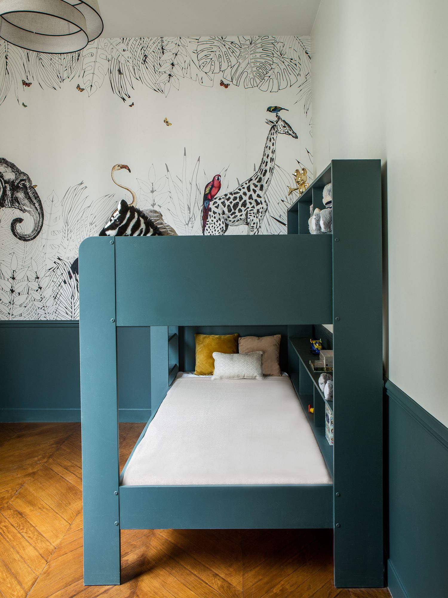 The children's bedroom features a darker teal shade that compliments the Les Dominotiers wallpaper and creates a relaxing haven