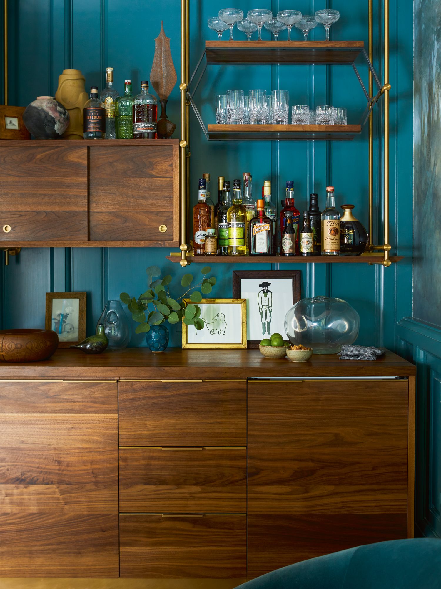 The open shelf unit showcases an assortment of liquors and glassware