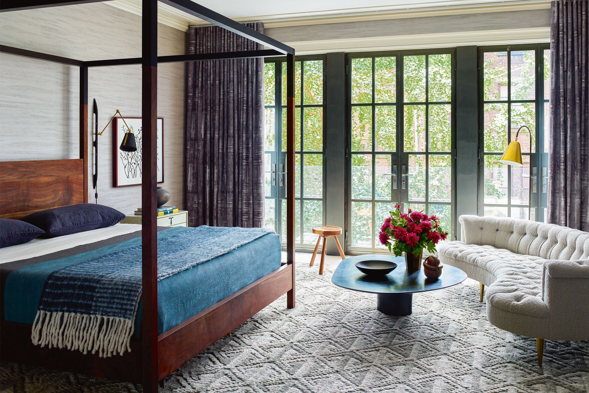 The master bedroom incorporates a vintage sofa and handcrafted four-poster bed