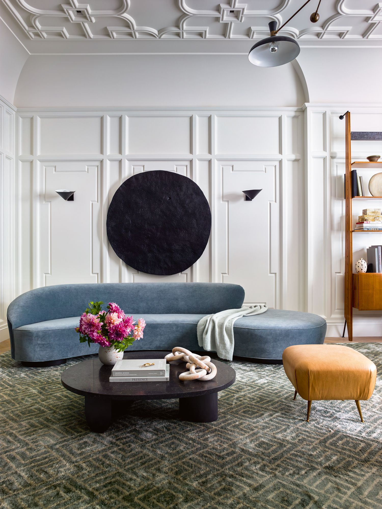 Curved furnishings such as this sofa from Vladimir Kagan balance the angular lines of the mouldings and shelves