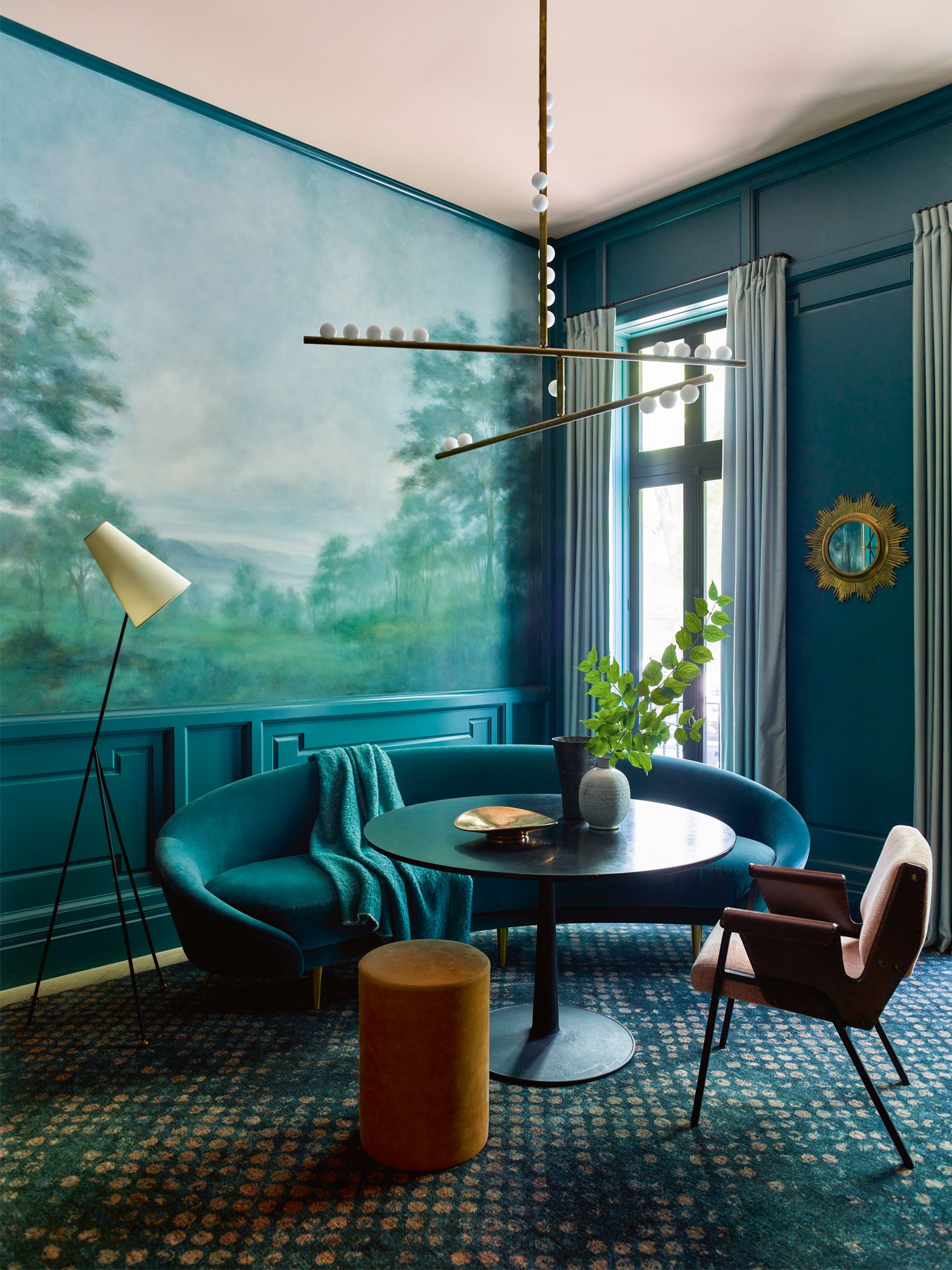 The teal tones in the lounge area are punctuated by the earthy hues of the mustard accent stool and leather armchair