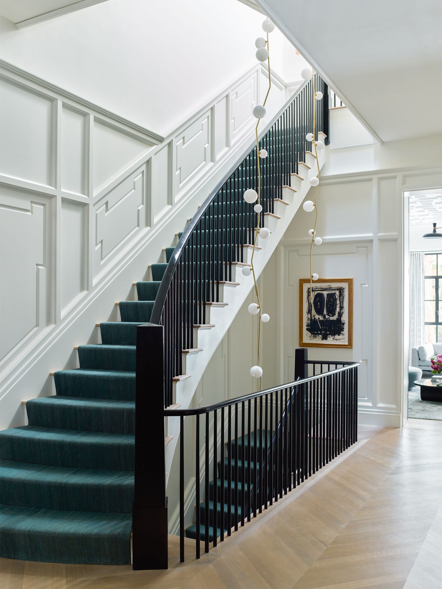 A pair of bespoke Lindsey Adelman chandeliers add character to the stairwell
