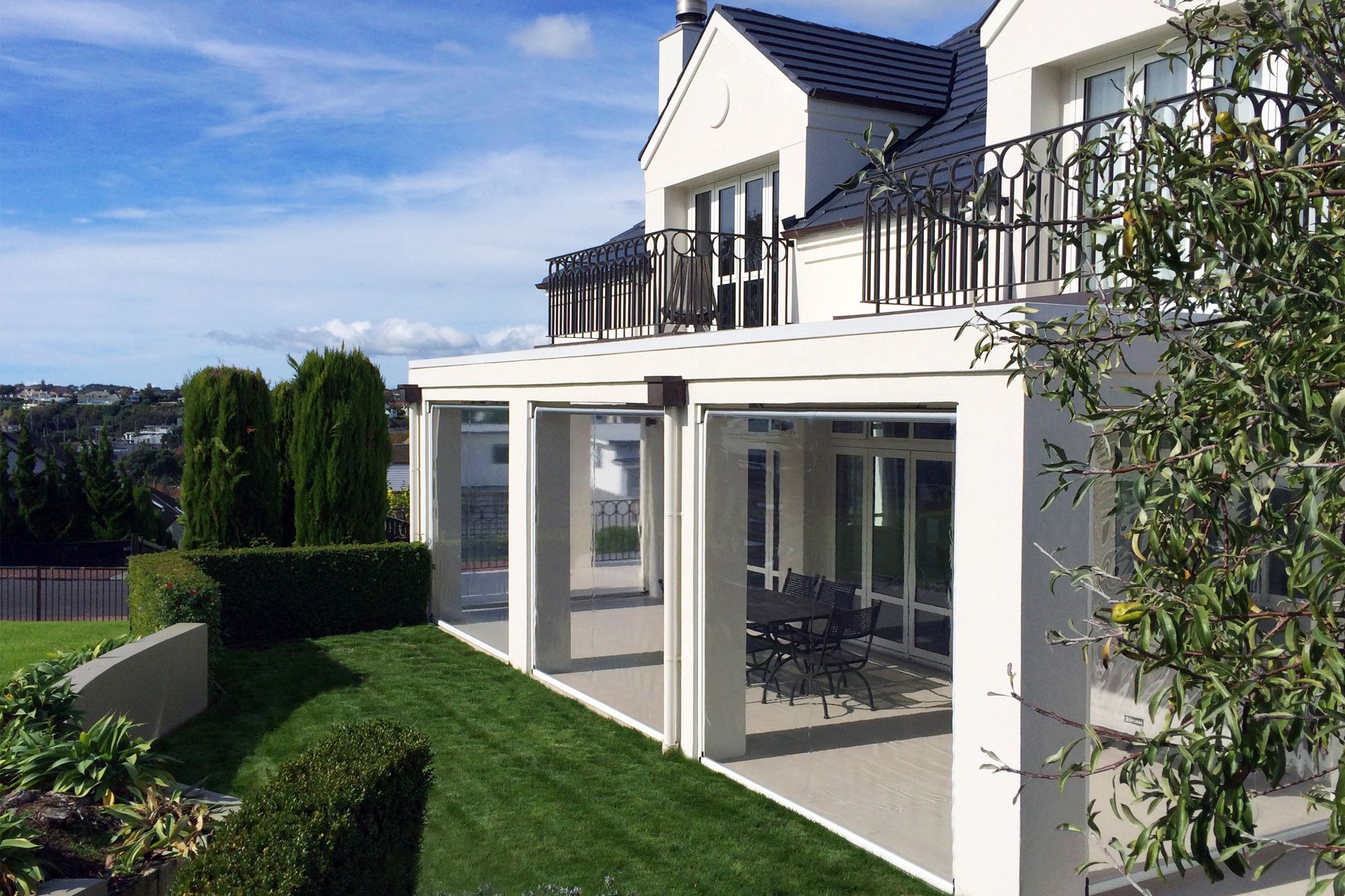 A view of a house with Ziptrak outdoor blinds installed at the patio