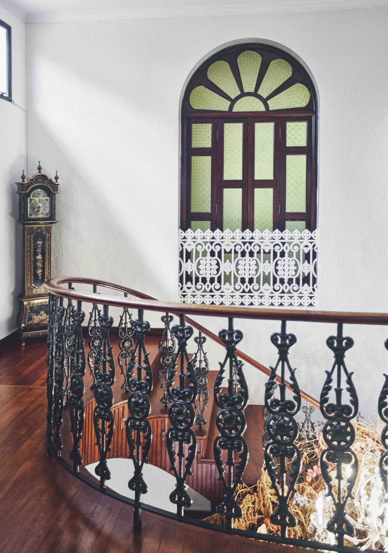 The couple decorated the space with vintage furnishings such as this antique grandfather clock, which pairs well with the intricate ironwork