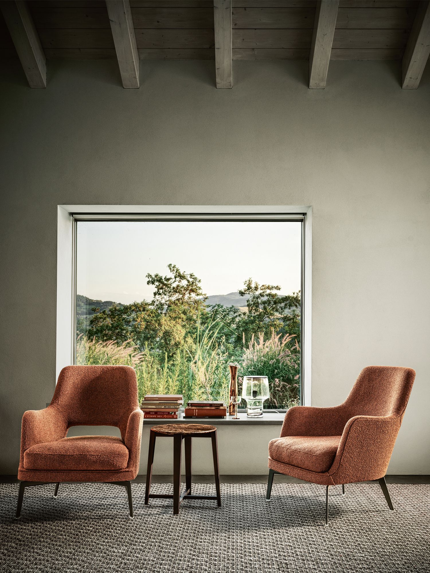 A pair of Gatsby armchairs and a Tris side table from Flexform hold court at the picture window