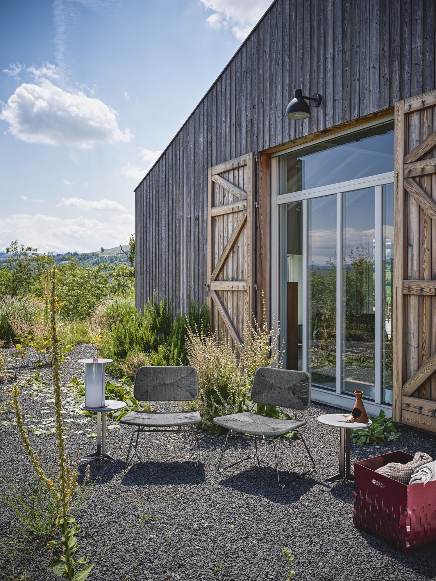 On the west side of the home, a pair of Flexform Echoes chairs is positioned for terrific views of the fields