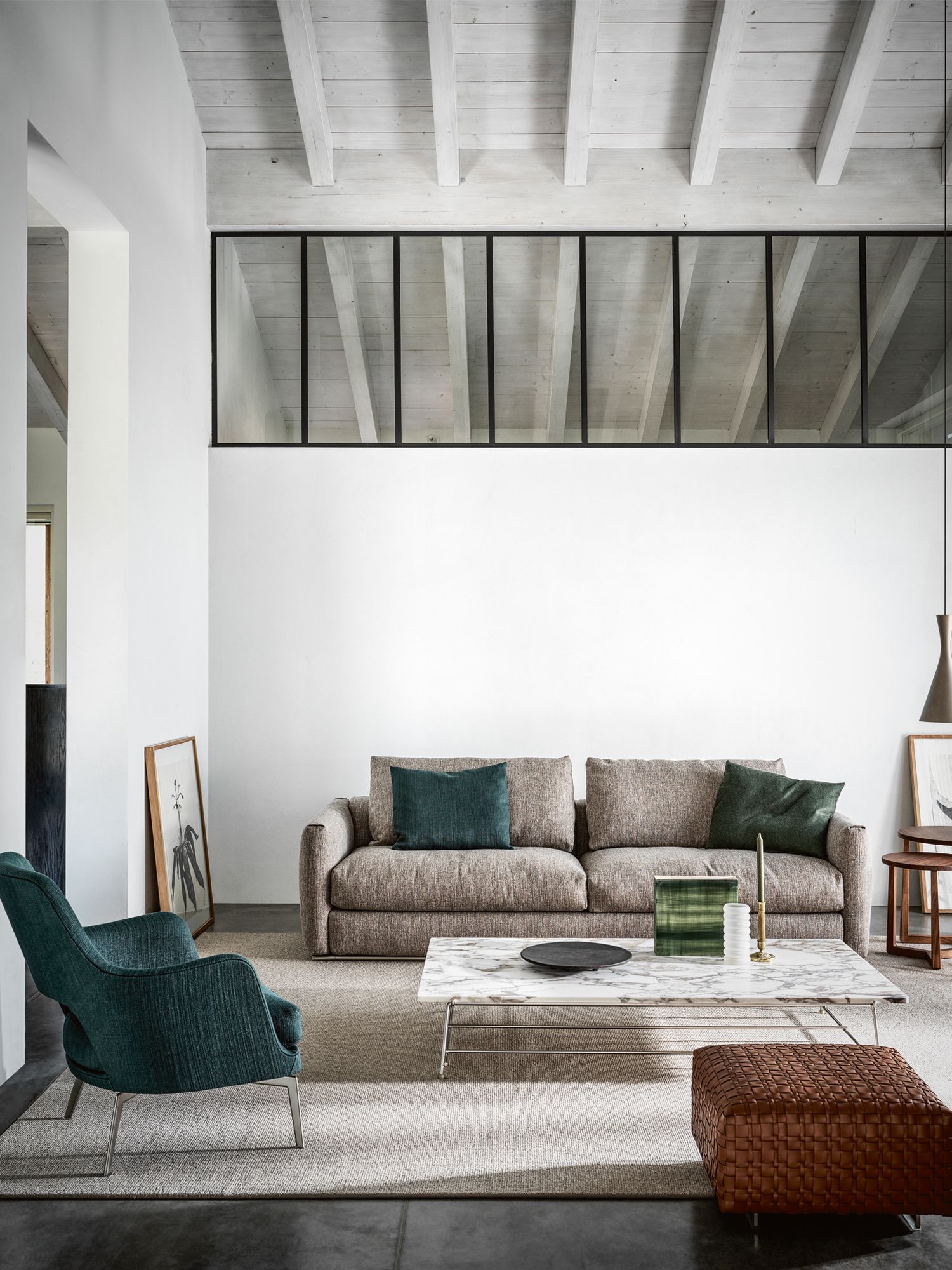 The living area features the Asolo sofa and Gatsby armchair by Antonio Citterio, Any Day coffee table by Christophe Pillet and Bangkok ottoman, all from Flexform