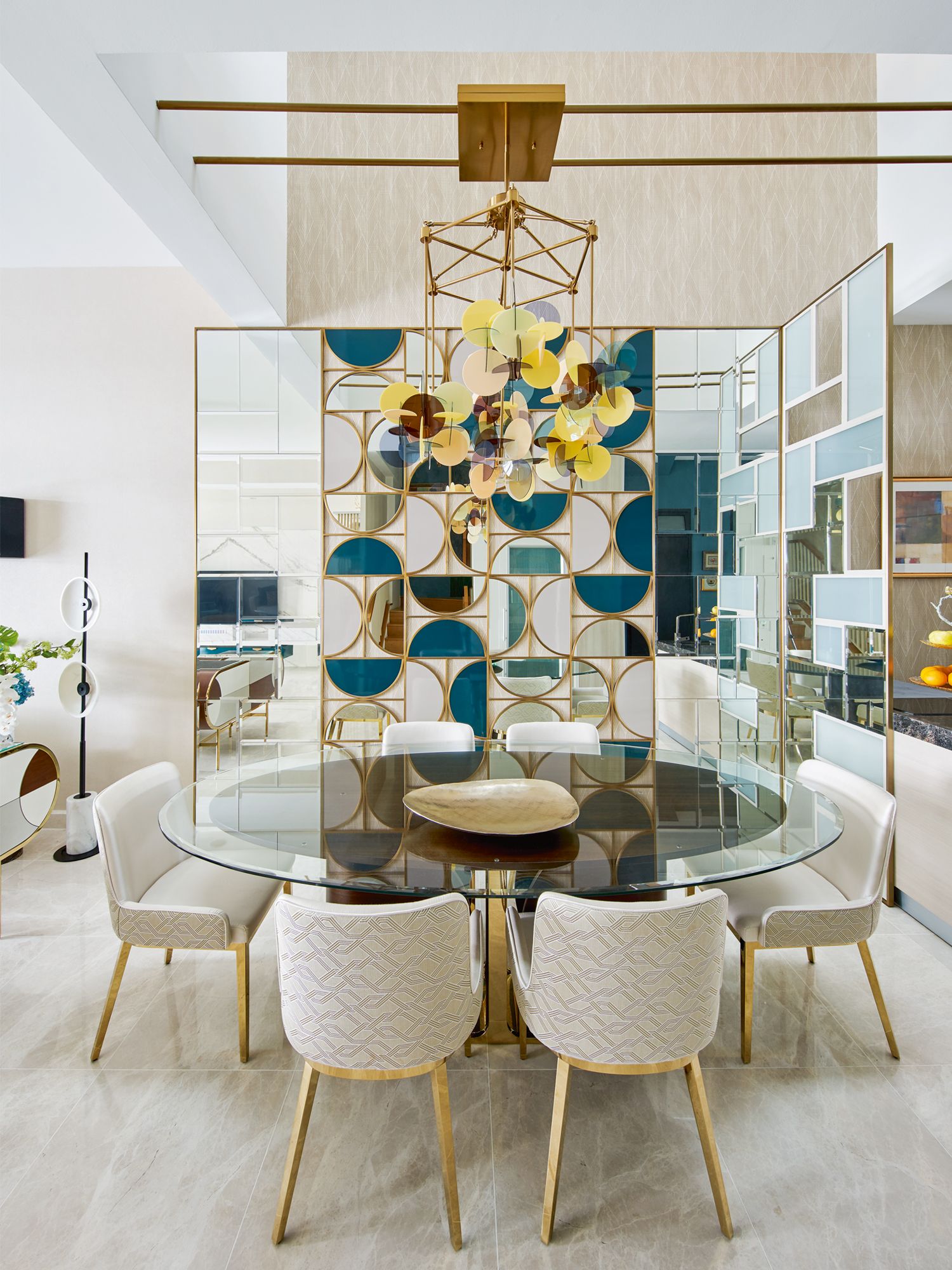 The glass divider and the striking chandelier delineate the dining zone on the open-plan first storey